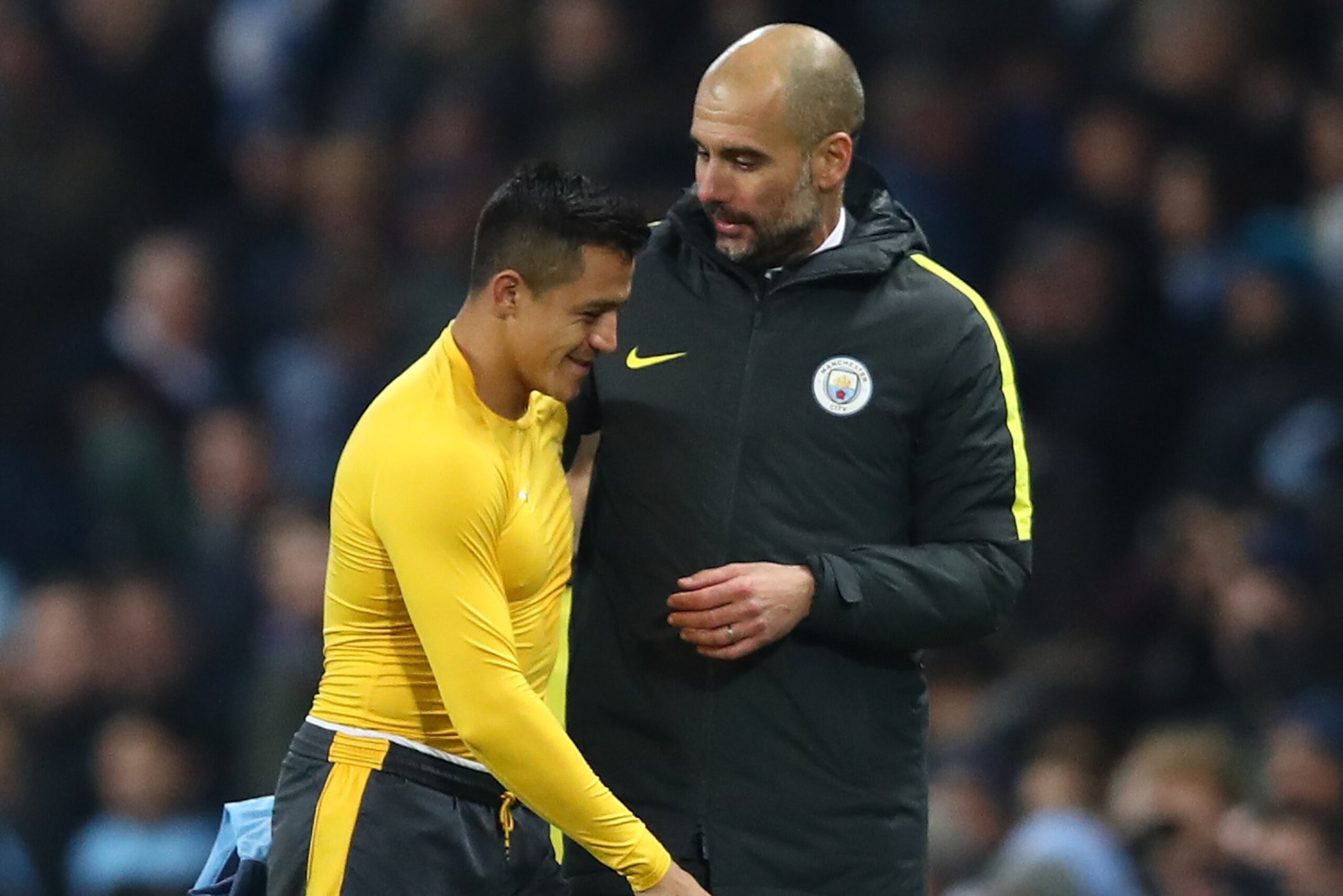 MANCHESTER, ENGLAND - DECEMBER 18:  Alexis Sanchez of Arsenal (L) and Josep Guardiola, Manager of Manchester City (R) embrace after the final whistle during the Premier League match between Manchester City and Arsenal at the Etihad Stadium on December 18,