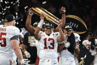 ATLANTA, GA - JANUARY 08: Tua Tagovailoa #13 of the Alabama Crimson Tide holds the trophy while celebrating with his team after defeating the Georgia Bulldogs in overtime to win the CFP National Championship presented by AT&T at Mercedes-Benz Stadium on J