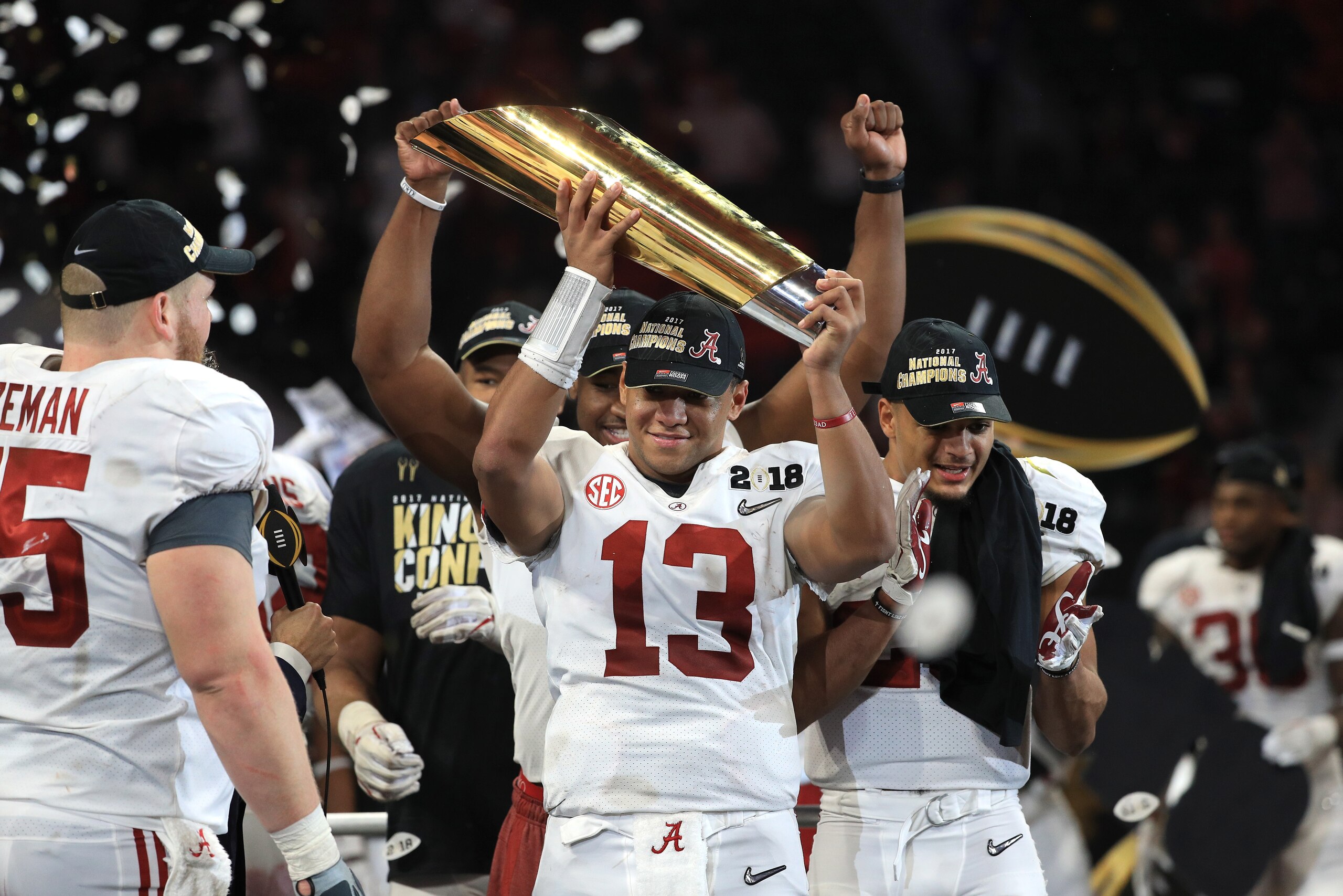 ATLANTA, GA - JANUARY 08: Tua Tagovailoa #13 of the Alabama Crimson Tide holds the trophy while celebrating with his team after defeating the Georgia Bulldogs in overtime to win the CFP National Championship presented by AT&T at Mercedes-Benz Stadium on J