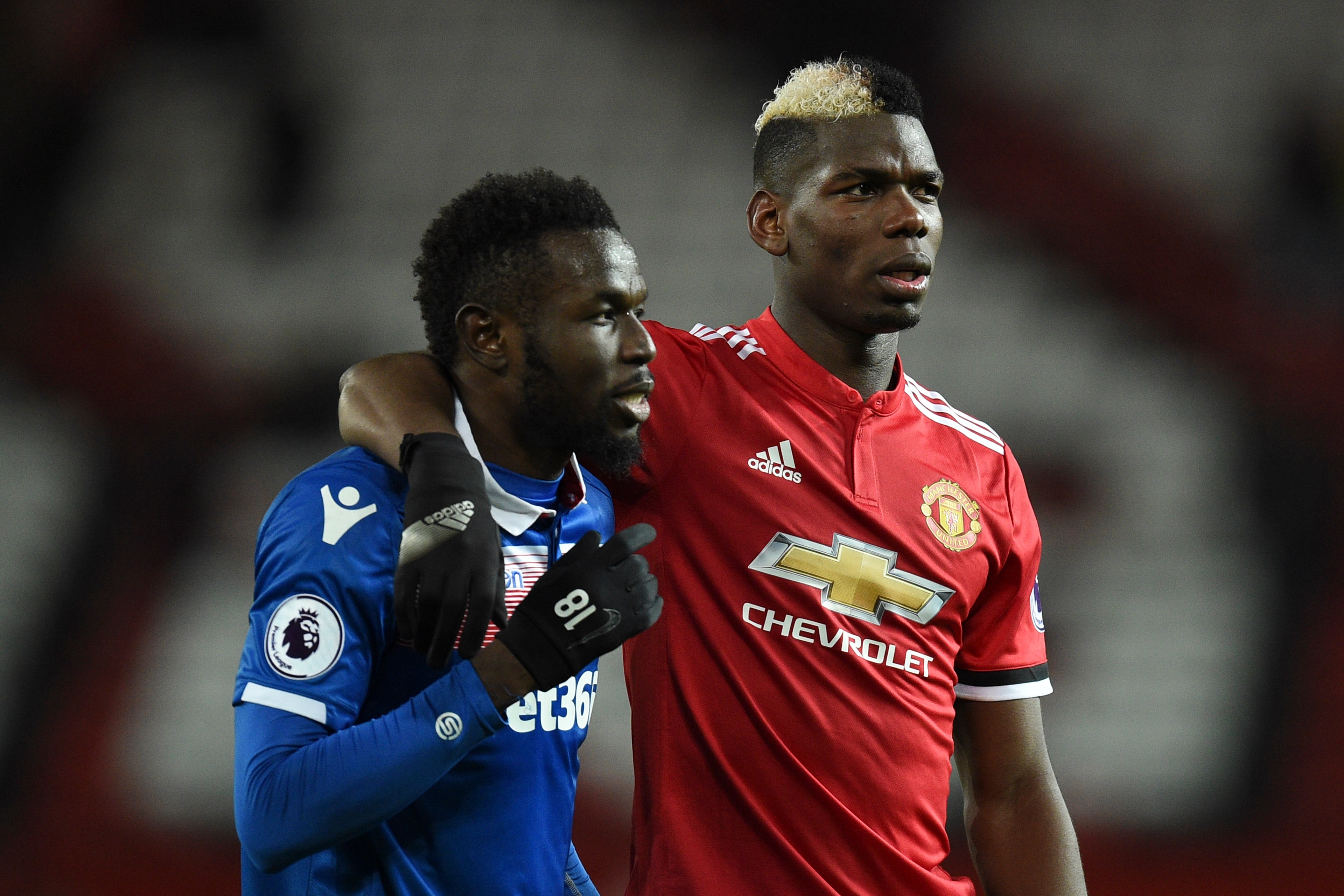 Manchester United's French midfielder Paul Pogba (R) embraces Stoke City's Senegalese striker Mame Biram Diouf (L) at the end of the English Premier League football match between Manchester United and Stoke City at Old Trafford in Manchester, north west E