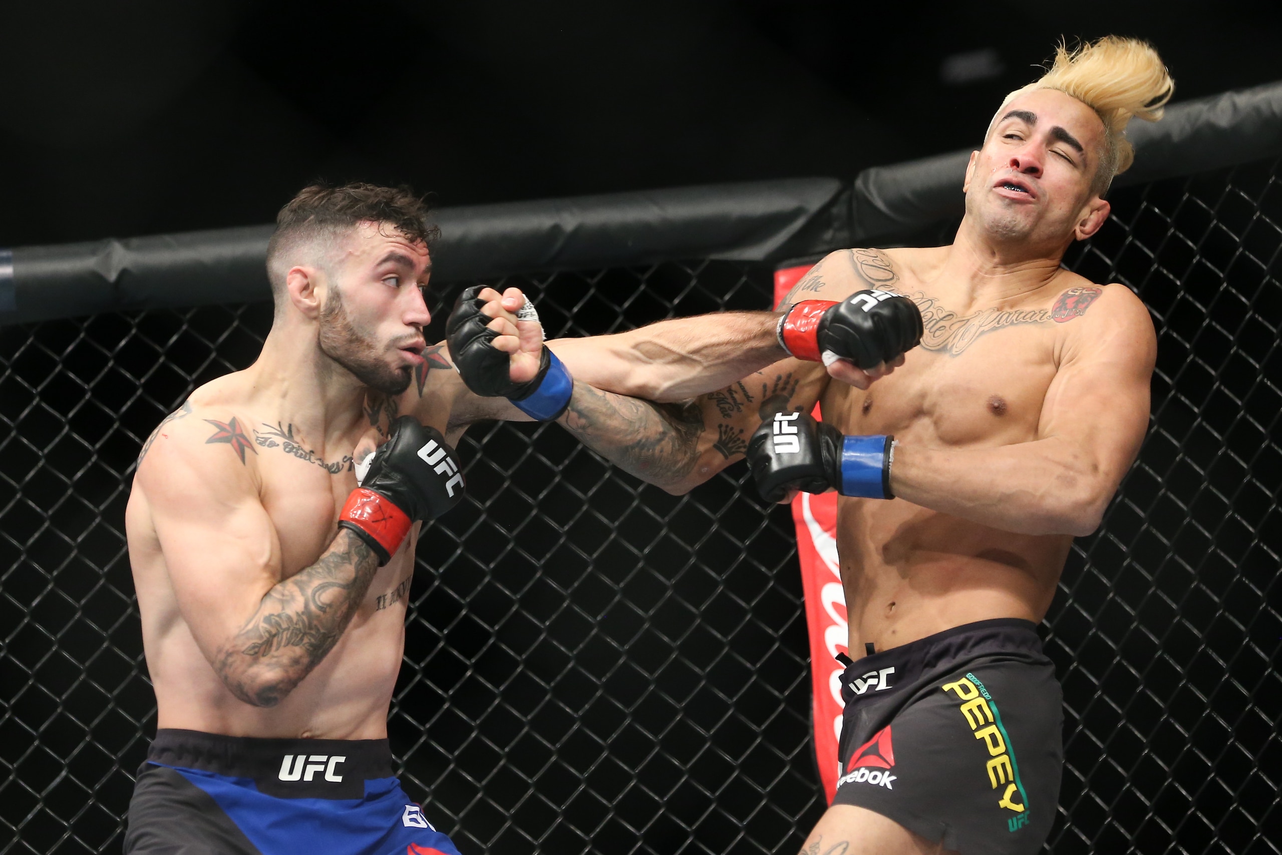 UNIONDALE, NY - JULY 22: Shane Burgos (L) lands a left hand on Godofredo Pepey (R) during their UFC Fight Night featherweight bout at the Nassau Veterans Memorial Coliseum on July 22, 2017 in Uniondale, New York. (Photo by Ed Mulholland/Getty Images)