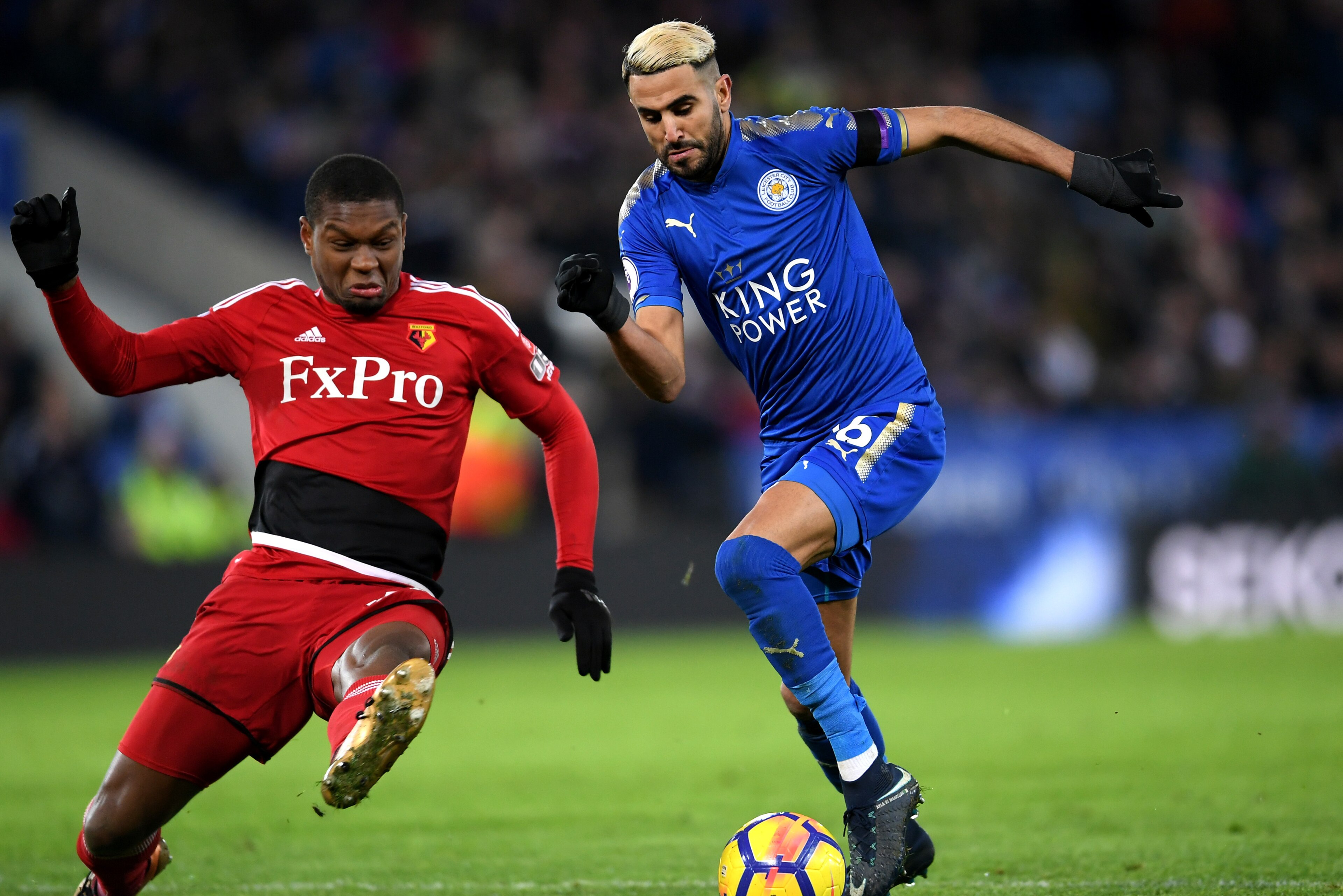 LEICESTER, ENGLAND - JANUARY 20:  Riyad Mahrez of Leicester City escapes a challenge from Marvin Zeegelaar of Watford on the way to the scoring his siddes first goal during the Premier League match between Leicester City and Watford at The King Power Stad