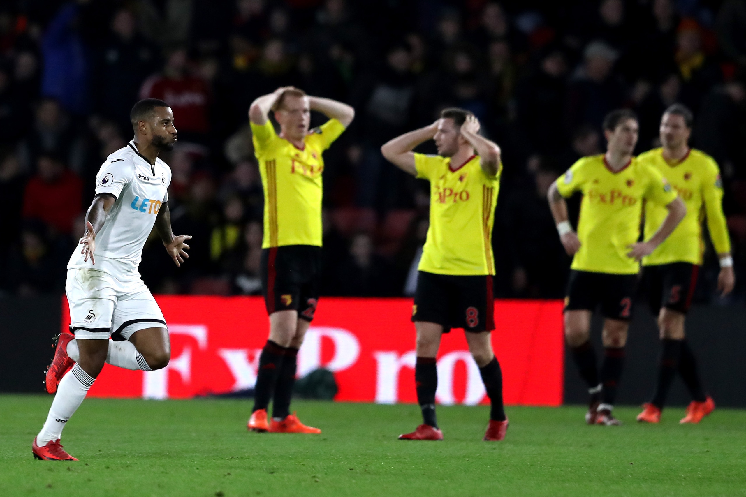 WATFORD, ENGLAND - DECEMBER 30:  Tom Cleverley of Watford and teammate Ben Watson look dejected as Luciano Narsingh of Swansea City celebrates after scoring his sides second goal during the Premier League match between Watford and Swansea City at Vicarage