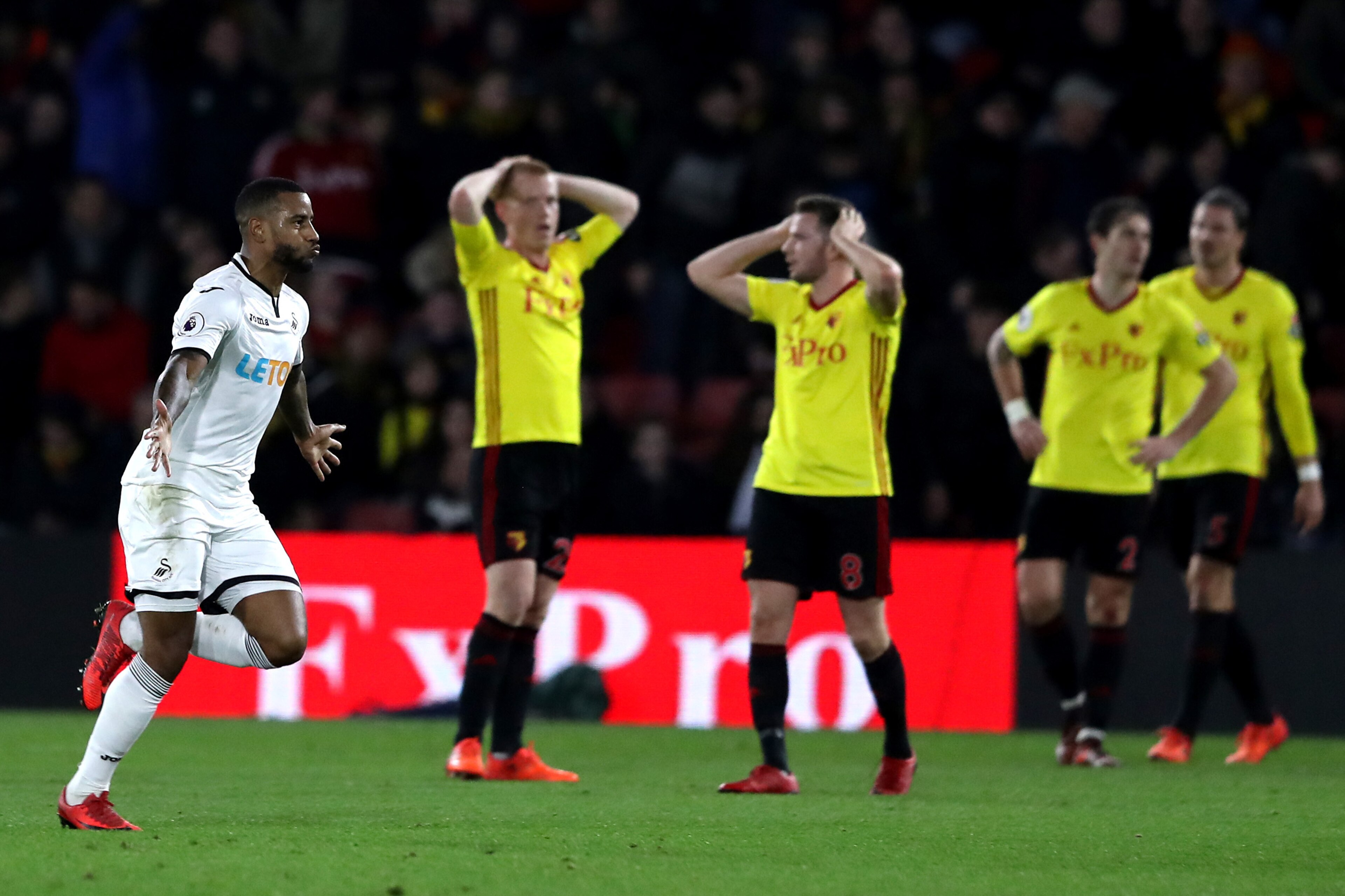 WATFORD, ENGLAND - DECEMBER 30:  Tom Cleverley of Watford and teammate Ben Watson look dejected as Luciano Narsingh of Swansea City celebrates after scoring his sides second goal during the Premier League match between Watford and Swansea City at Vicarage