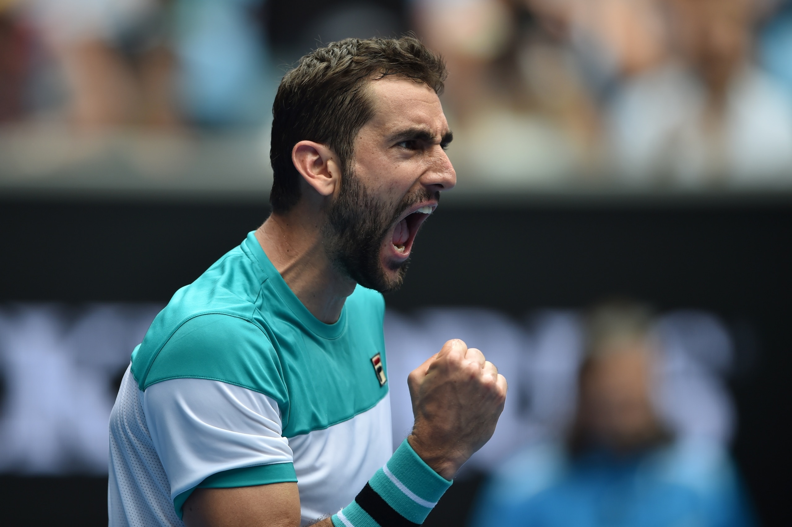 TOPSHOT - Croatia's Marin Cilic celebrates beating Spain's Pablo Carreno Busta in their men's singles fourth round match on day seven of the Australian Open tennis tournament in Melbourne on January 21, 2018. / AFP PHOTO / PETER PARKS / -- IMAGE RESTRICTE
