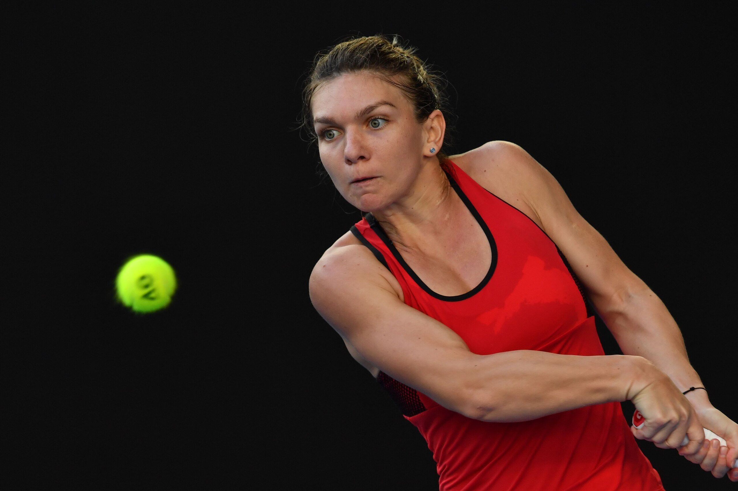 Romania's Simona Halep plays a backhand return to Japan's Naomi Osaka during their women's singles fourth round match on day eight of the Australian Open tennis tournament in Melbourne on January 22, 2018. / AFP PHOTO / Paul Crock / -- IMAGE RESTRICTED TO