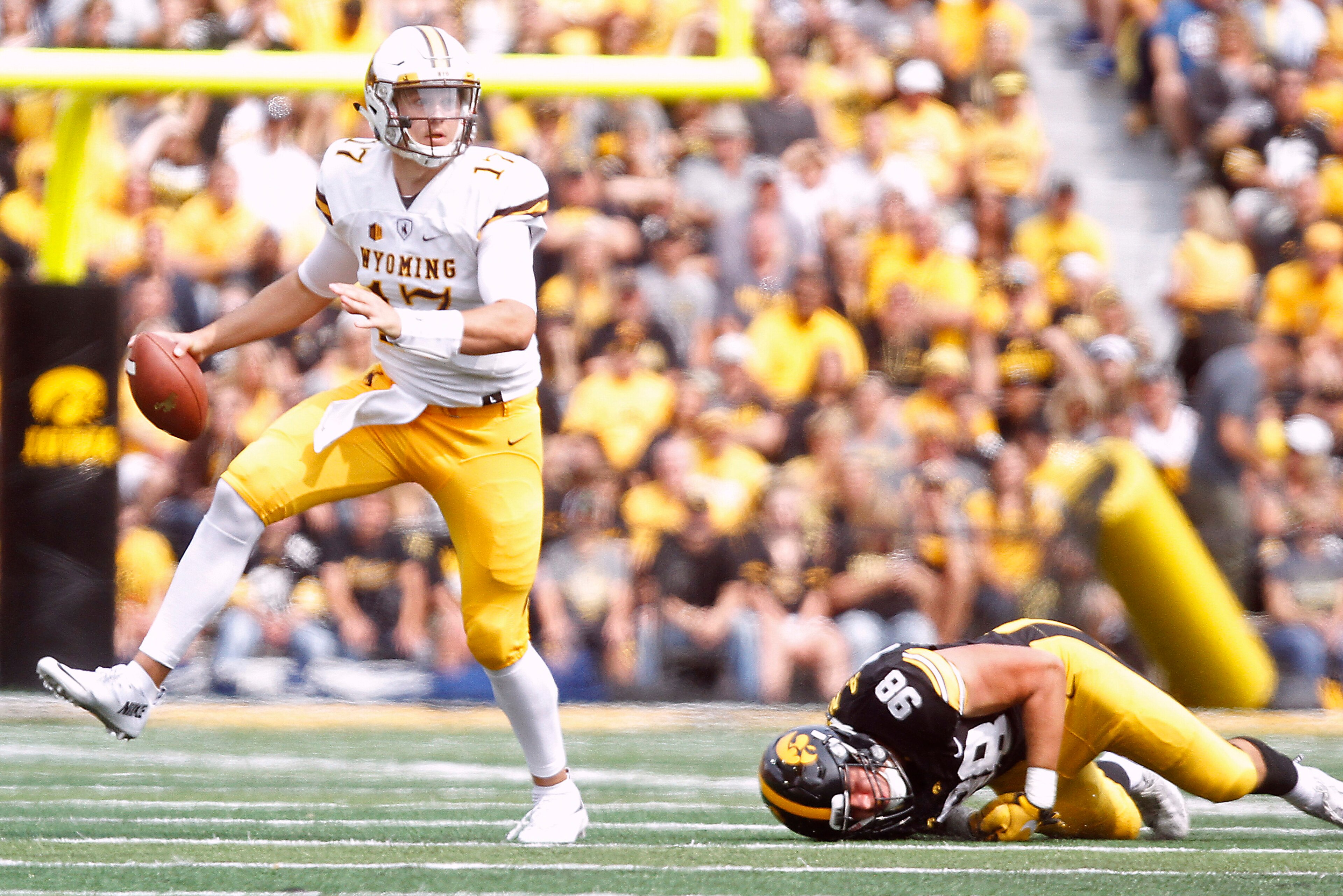 IOWA CITY, IOWA- SEPTEMBER 2:  Quarterback Josh Allen #17 of the Wyoming Cowboys escapes a tackle from defensive end Anthony Nelson #98 of the Iowa Hawkeyes during the second quarter, on September 2, 2017 at Kinnick Stadium in Iowa City, Iowa.  (Photo by 