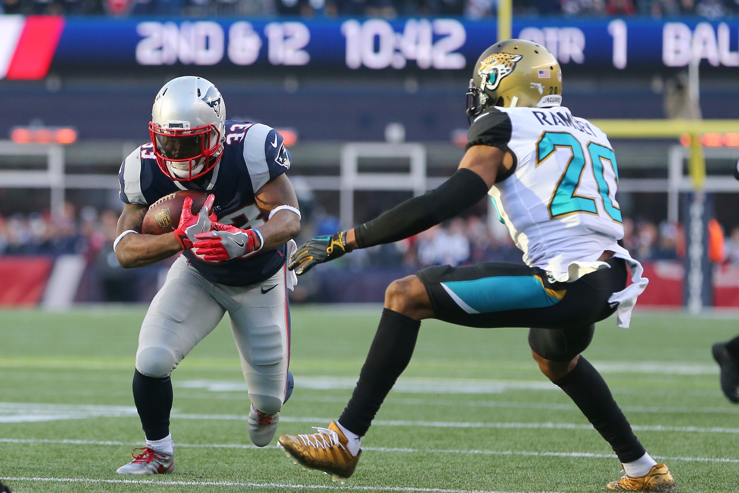 FOXBOROUGH, MA - JANUARY 21:  Dion Lewis #33 of the New England Patriots carries the ball as he  is defended by Jalen Ramsey #20 of the Jacksonville Jaguars  in the first quarter during the AFC Championship Game at Gillette Stadium on January 21, 2018 in 