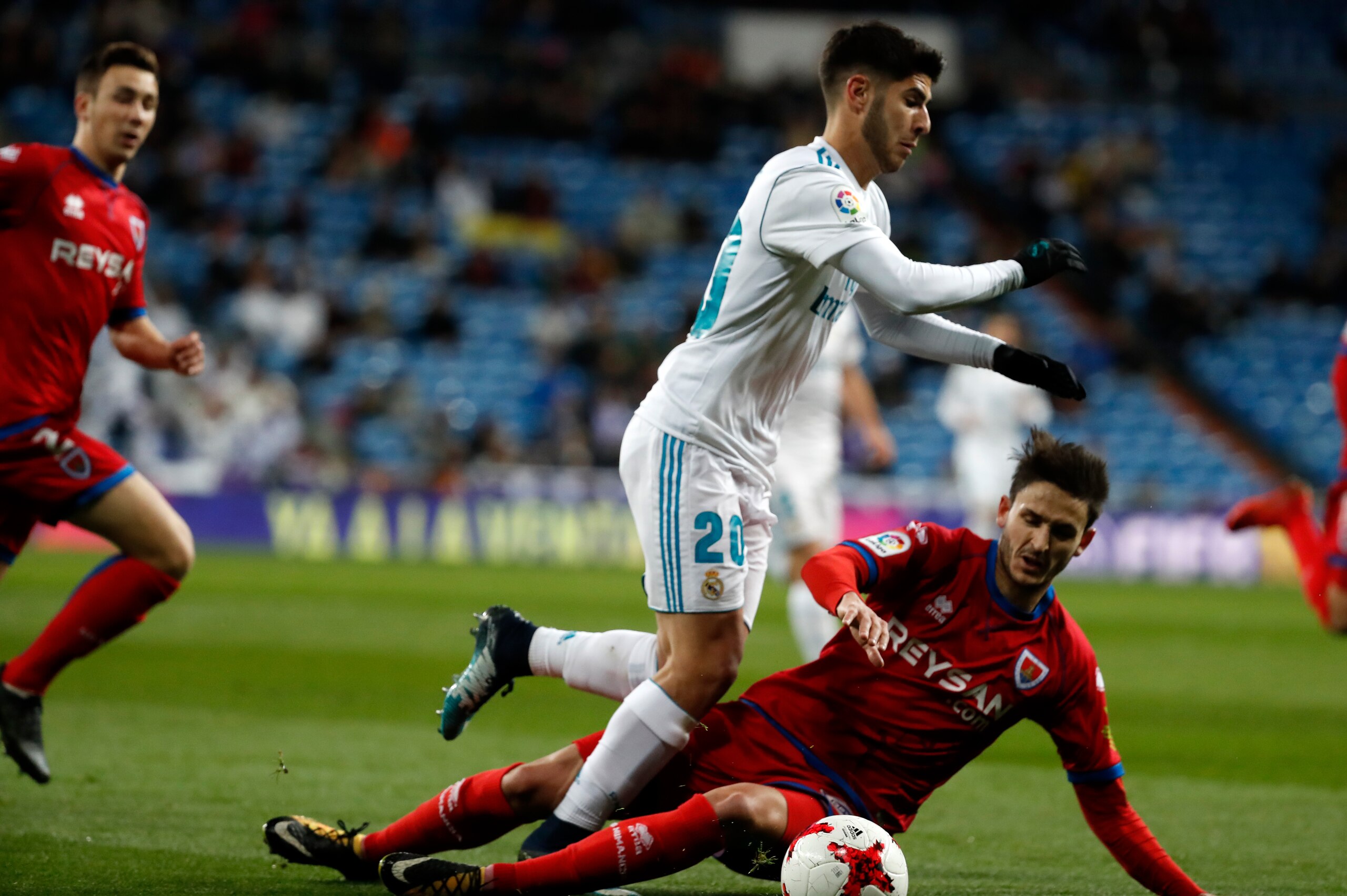 MADRID, SPAIN - JANUARY 10: Marco Asensio of Real Madrid and a player of Numancia battle for the ball during the Spanish Copa del Rey match between Real Madrid and Numancia at Santiago Bernabeu on January 10, 2018 in Madrid, Spain. (Photo by TF-Images/TF-