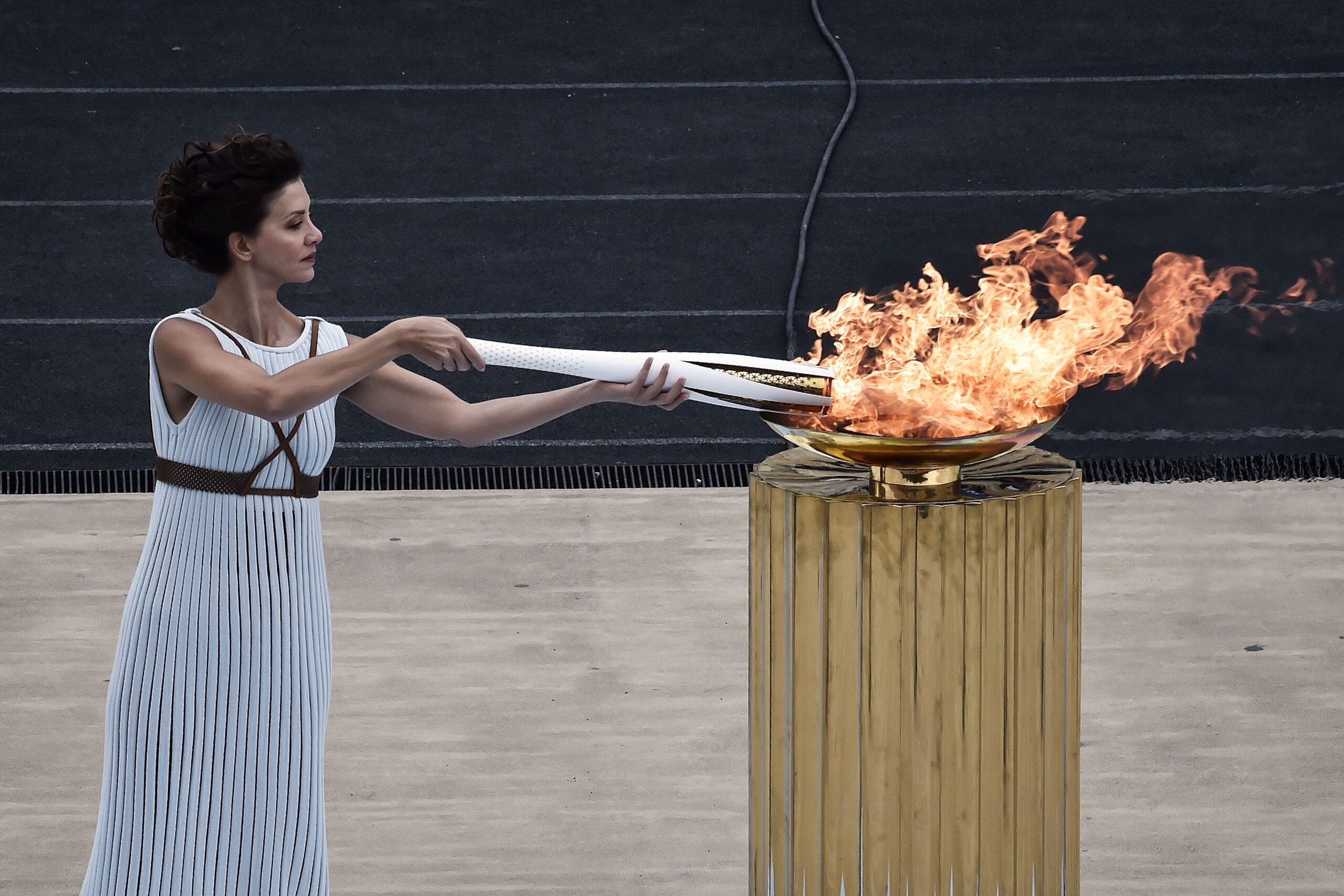 TOPSHOT - Actress Katerina Lechou, performing a high priestess lights the olympic torch, at The Panathenaic Stadium in Athens on October 31, 2017, during the handover ceremony of the Olympic flame for the 2018 Winter Olympics in Pyeongchang, South Korea. 