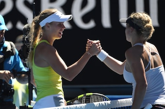 Denmark's Caroline Wozniacki (L) shakes hands with Croatia's Jana Fett after winning their women's singles second round match on day three of the Australian Open tennis tournament in Melbourne on January 17, 2018. / AFP PHOTO / WILLIAM WEST / -- IMAGE RES