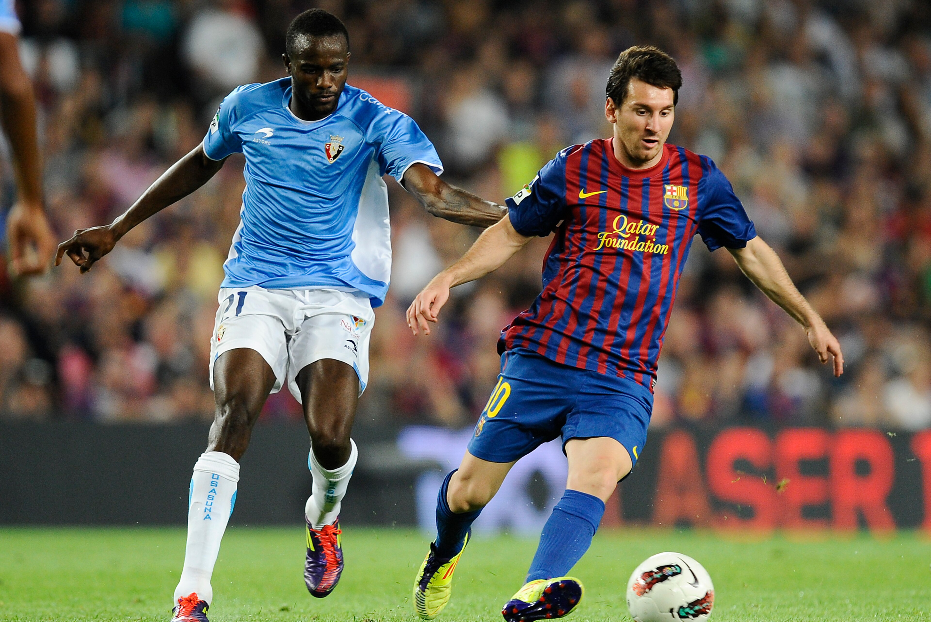 BARCELONA, SPAIN - SEPTEMBER 17: Lionel Messi (R) of FC Barcelona competes for the ball with Roland Lamah of CA Osasuna during the La Liga soccer match between FC Barcelona and CA Osasuna at Camp Nou Stadium on September 17, 2011 in Barcelona, Spain. (P BARCELONA, SPAIN - SEPTEMBER 17: Lionel Messi (R) of FC Barcelona competes for the ball with Roland Lamah of CA Osasuna during the La Liga soccer match between FC Barcelona and CA Osasuna at Camp Nou Stadium on September 17, 2011 in Barcelona, Spain. (P