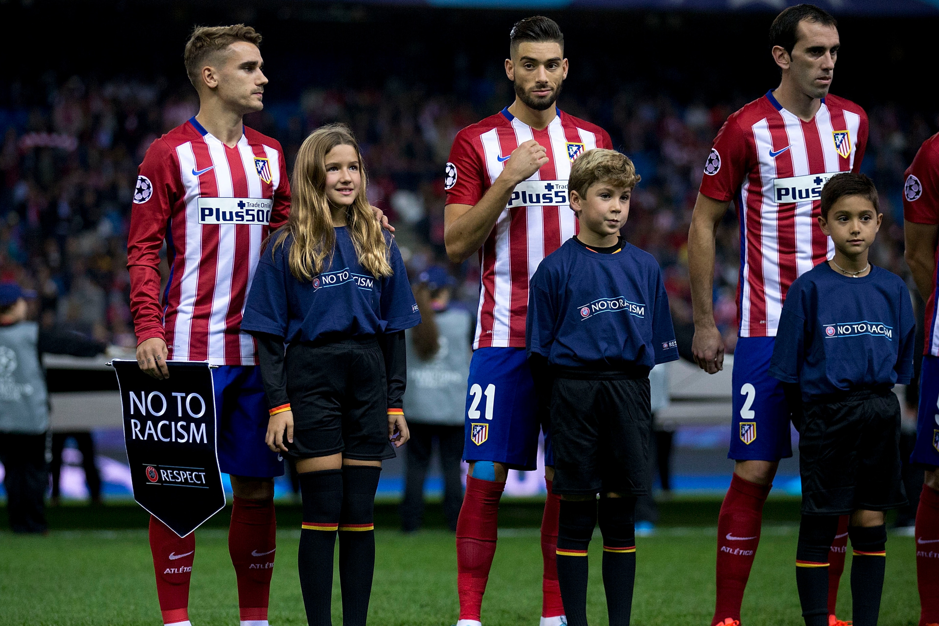 MADRID, SPAIN - OCTOBER 21: Antoine Griezmann (L) of Atletico de Madrid holds the UEFA No To Racism pennant close to his teammates Yannick Carrasco (2ndL) and Juan Francisco Torres alias Juanfran (R) behind all of them behind the escort kids prior to sta MADRID, SPAIN - OCTOBER 21: Antoine Griezmann (L) of Atletico de Madrid holds the UEFA No To Racism pennant close to his teammates Yannick Carrasco (2ndL) and Juan Francisco Torres alias Juanfran (R) behind all of them behind the escort kids prior to sta