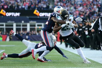 FOXBOROUGH, MA - JANUARY 21:  T.J. Yeldon #24 of the Jacksonville Jaguars carries the ball as he is defended by Patrick Chung #23 of the New England Patriots and Stephone Gilmore #24  in the first half  during the AFC Championship Game at Gillette Stadium