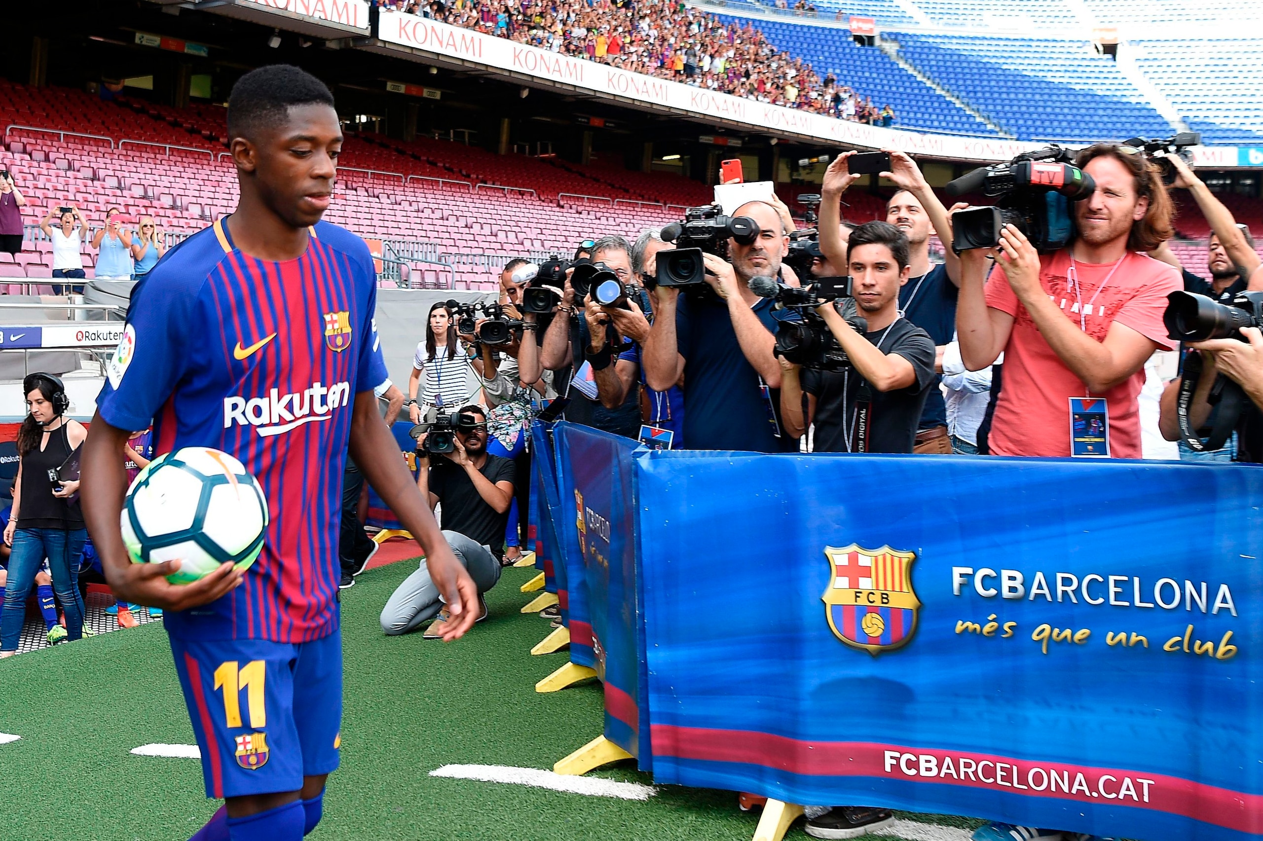 Barcelona's new player Ousmane Dembele (L) enters the pitch at the Camp Nou stadium in Barcelona, during his official presentation by the Catalan football club, on August 28, 2017.
French starlet Ousmane Dembele agreed a five-year deal with Barcelona wort Barcelona's new player Ousmane Dembele (L) enters the pitch at the Camp Nou stadium in Barcelona, during his official presentation by the Catalan football club, on August 28, 2017.
French starlet Ousmane Dembele agreed a five-year deal with Barcelona wort