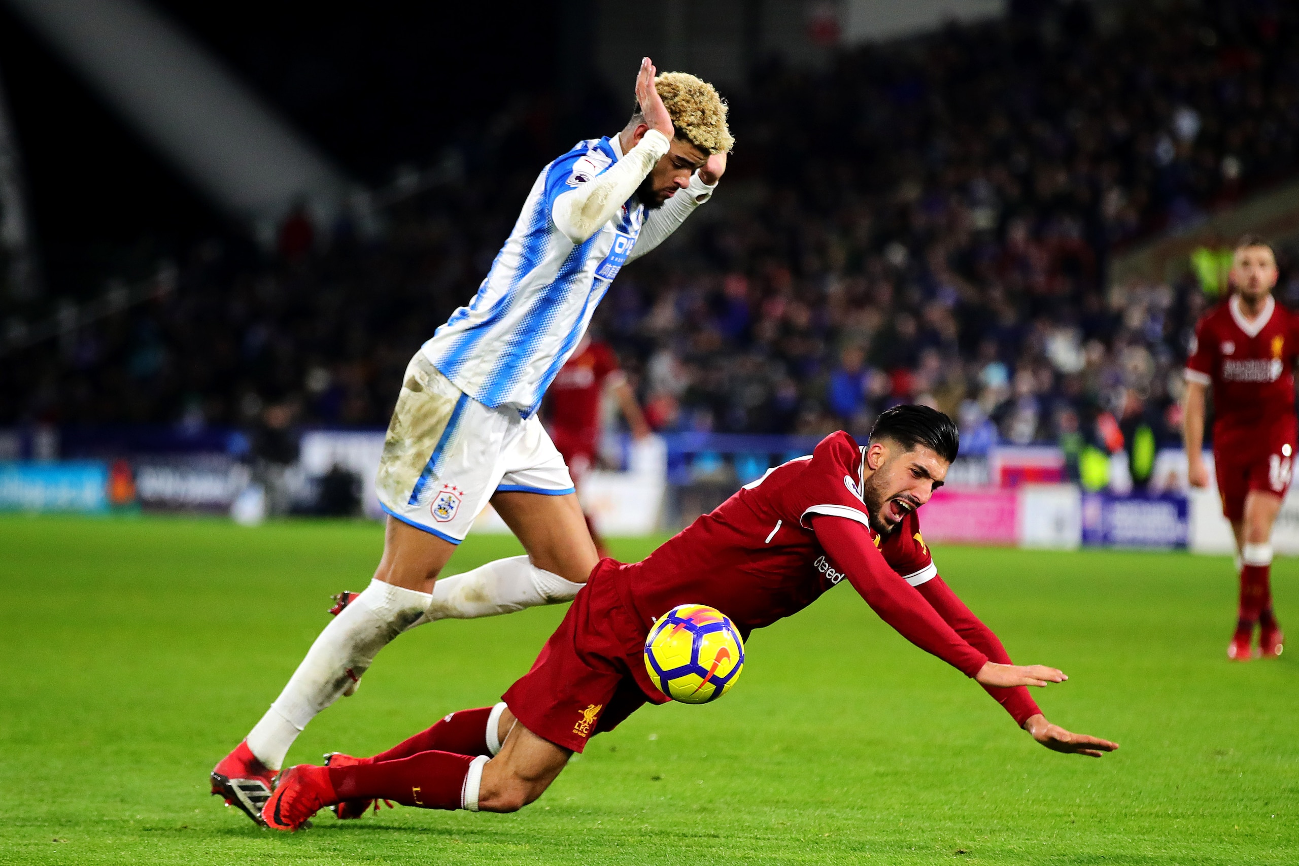 HUDDERSFIELD, ENGLAND - JANUARY 30: Philip Billing of Huddersfield Town fouls Emre Can of Liverpool for a penalty during the Premier League match between Huddersfield Town and Liverpool at John Smith's Stadium on January 30, 2018 in Huddersfield, England.
