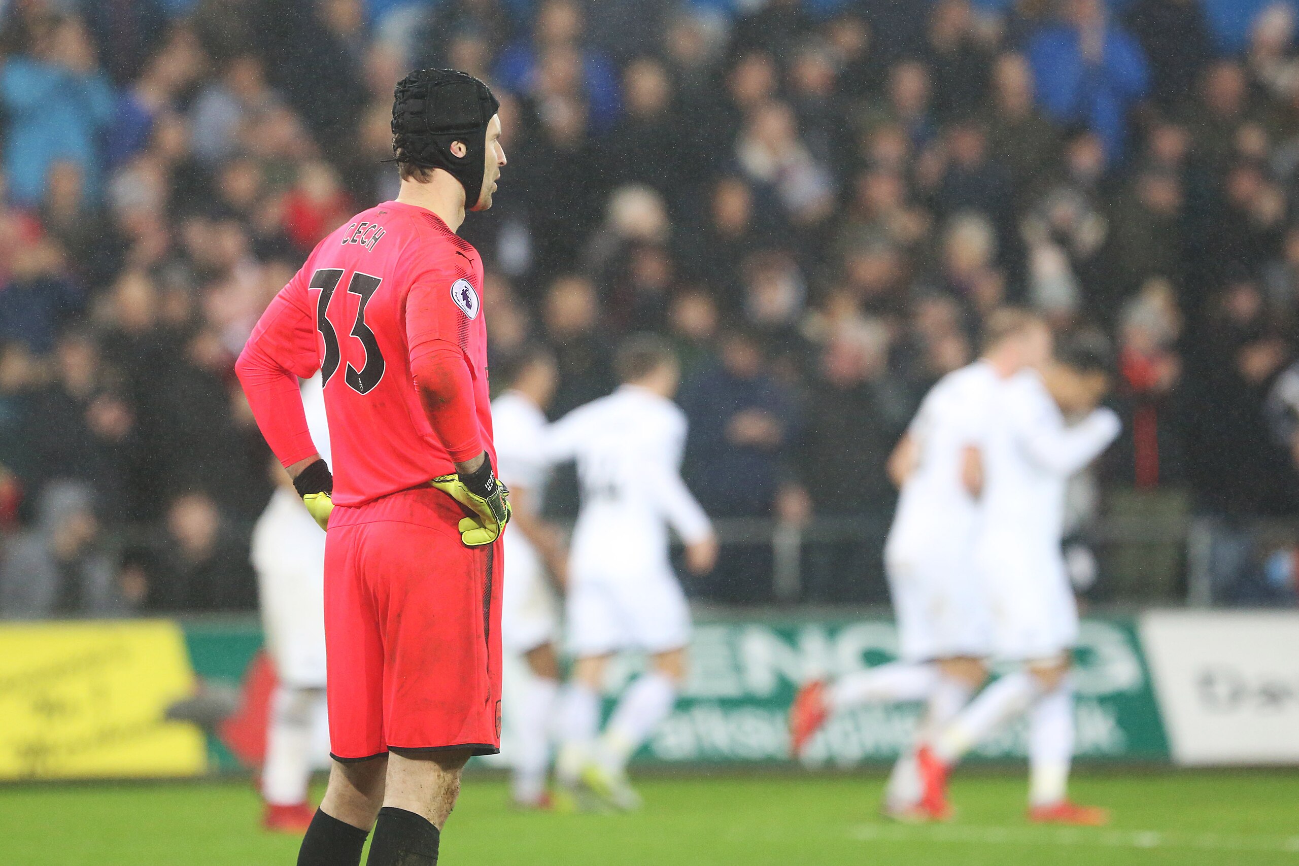 SWANSEA, WALES - JANUARY 30: Petr Cech of Arsenal looks dejected as Sam Clucas of Swansea celebrates scoring his sides third goal of the match during the Premier League match between Swansea City and Arsenal at the Liberty Stadium on January 30, 2018 in S