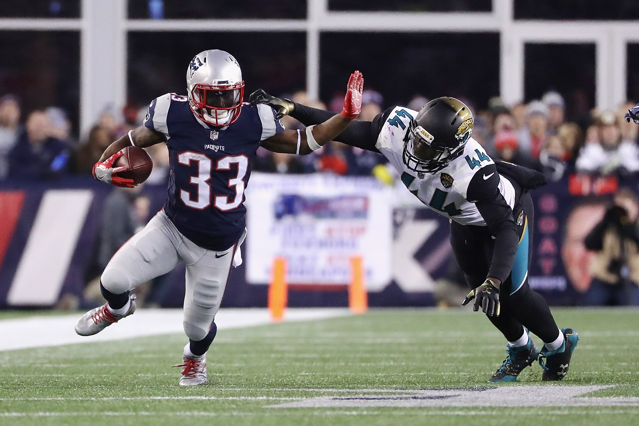 FOXBOROUGH, MA - JANUARY 21: Dion Lewis #33 of the New England Patriots carries the ball as he is defended by Myles Jack #44 of the Jacksonville Jaguars in the third quarter  during the AFC Championship Game at Gillette Stadium on January 21, 2018 in Foxb