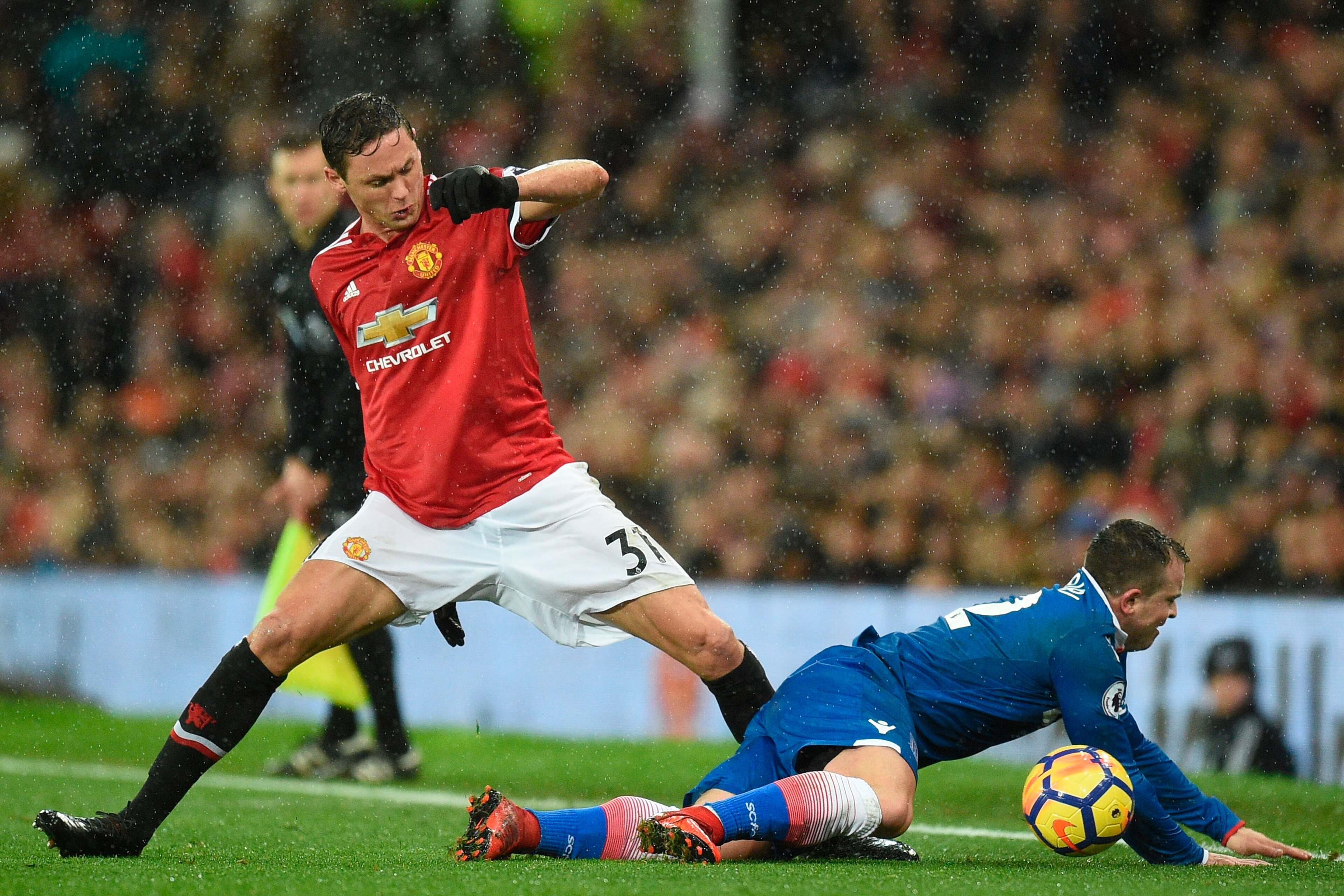 Manchester United's Serbian midfielder Nemanja Matic (L) fouls Stoke City's Swiss forward Xherdan Shaqiri (R) during the English Premier League football match between Manchester United and Stoke City at Old Trafford in Manchester, north west England, on J