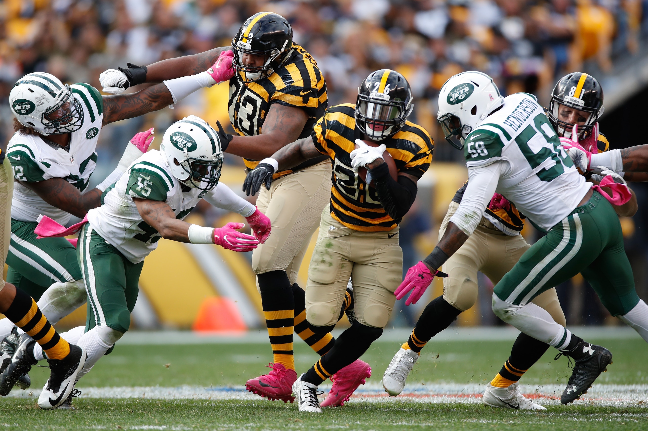 PITTSBURGH, PA - OCTOBER 09:  Le'Veon Bell #26 of the Pittsburgh Steelers tries to split the defense of Rontez Miles #45 and Erin Henderson #58 during a fourth quarter run at Heinz Field on October 9, 2016 in Pittsburgh, Pennsylvania. Pittsburgh won the g