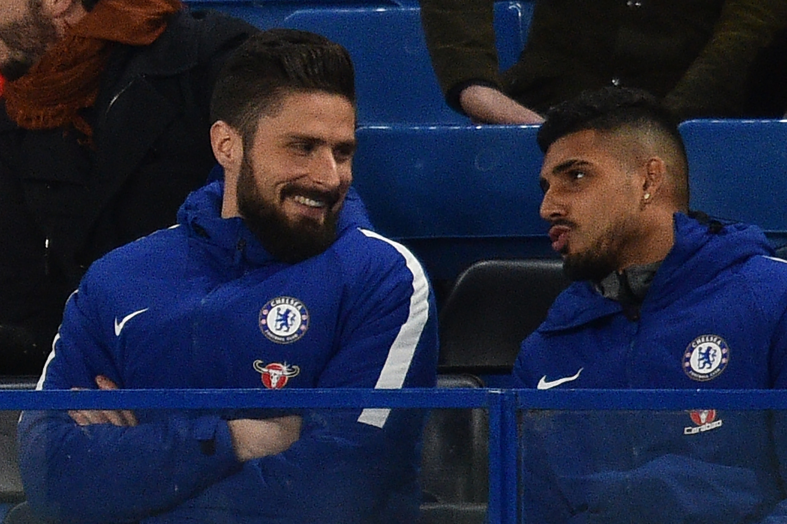 Newly-signed Chelsea striker Olivier Giroud (L) sits with the team before the English Premier League football match between Chelsea and Bournemouth at Stamford Bridge in London on January 31, 2018. / AFP PHOTO / Glyn KIRK / RESTRICTED TO EDITORIAL USE. No