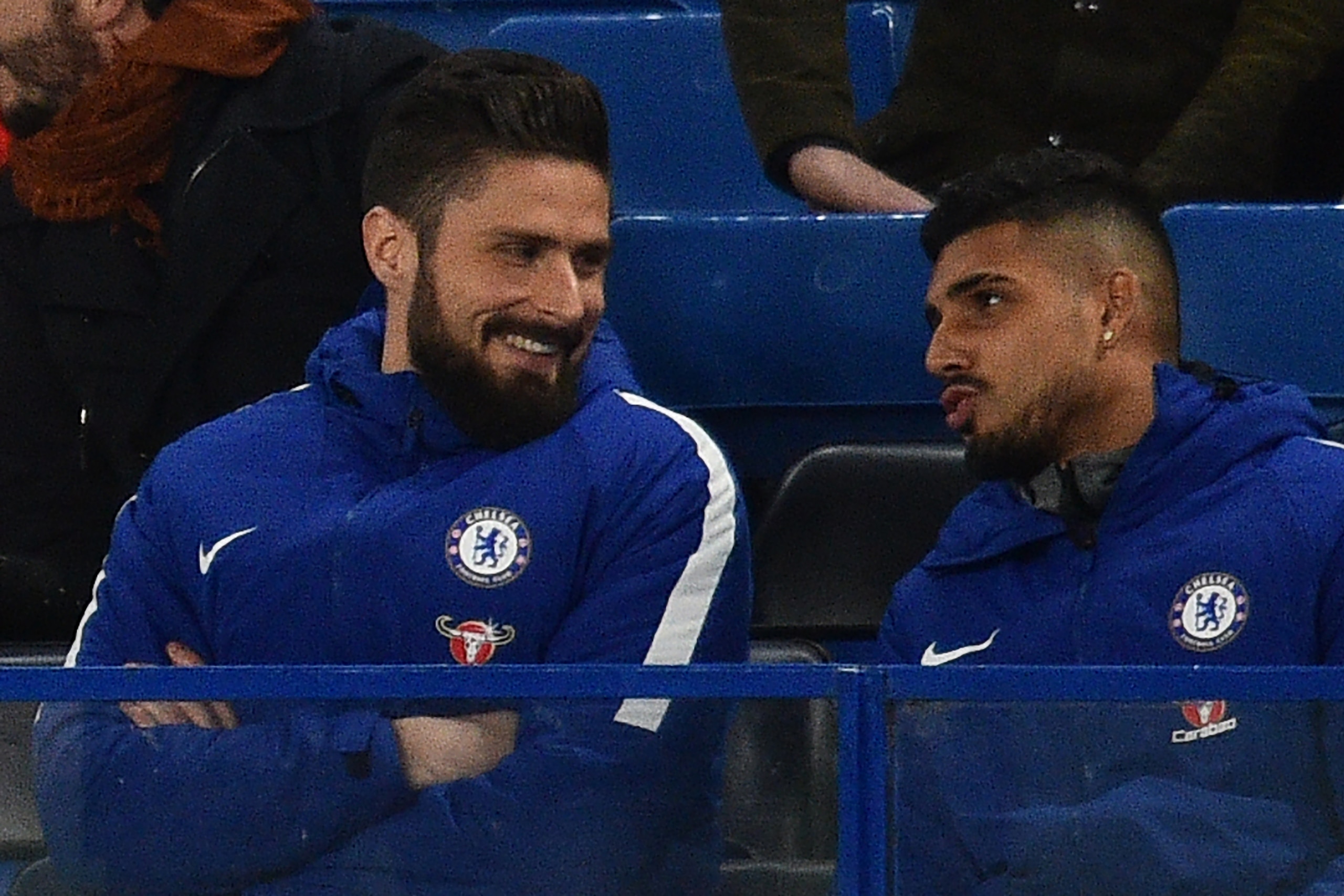 Newly-signed Chelsea striker Olivier Giroud (L) sits with the team before the English Premier League football match between Chelsea and Bournemouth at Stamford Bridge in London on January 31, 2018. / AFP PHOTO / Glyn KIRK / RESTRICTED TO EDITORIAL USE. No