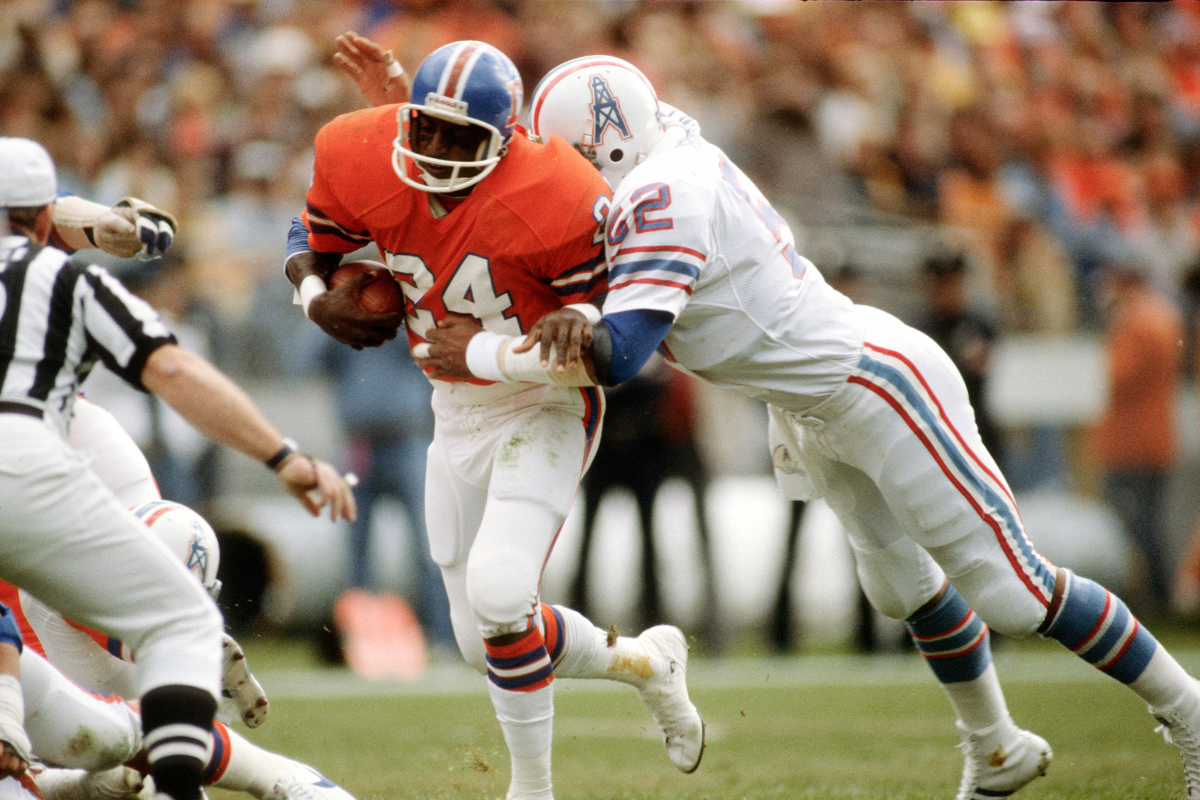 DENVER, CO - November 2: Otis Armstrong #24 of the Denver Broncos gets tackled by Robert Brazile #52 of the Houston Oilers during an NFL football game November 2, 1980 at Mile High Stadium in Denver, Colorado. Brazile played for the Oilers from 1975-84. (