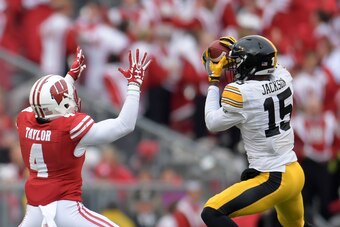 MADISON, WI - NOVEMBER 11:  Joshua Jackson #15 of the Iowa Hawkeyes intercepts a pass intended for A.J. Taylor #4 of the Wisconsin Badgers and returns it for a touchdown during the first quarter of a game at Camp Randall Stadium on November 11, 2017 in Ma