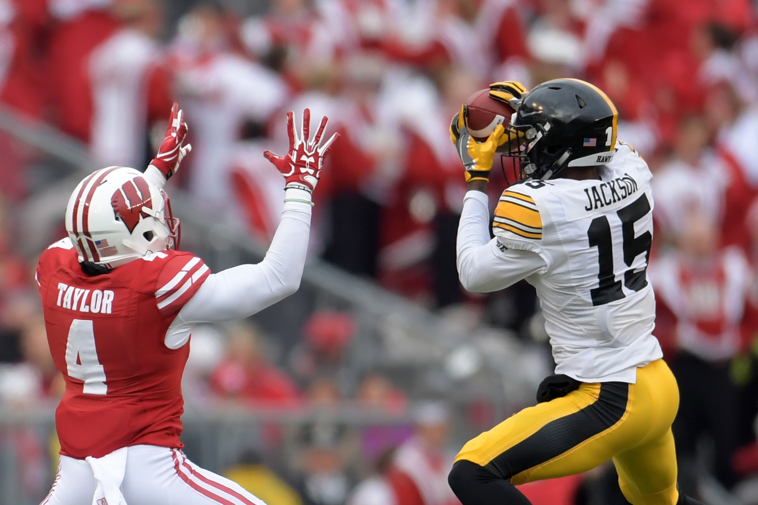 MADISON, WI - NOVEMBER 11:  Joshua Jackson #15 of the Iowa Hawkeyes intercepts a pass intended for A.J. Taylor #4 of the Wisconsin Badgers and returns it for a touchdown during the first quarter of a game at Camp Randall Stadium on November 11, 2017 in Ma