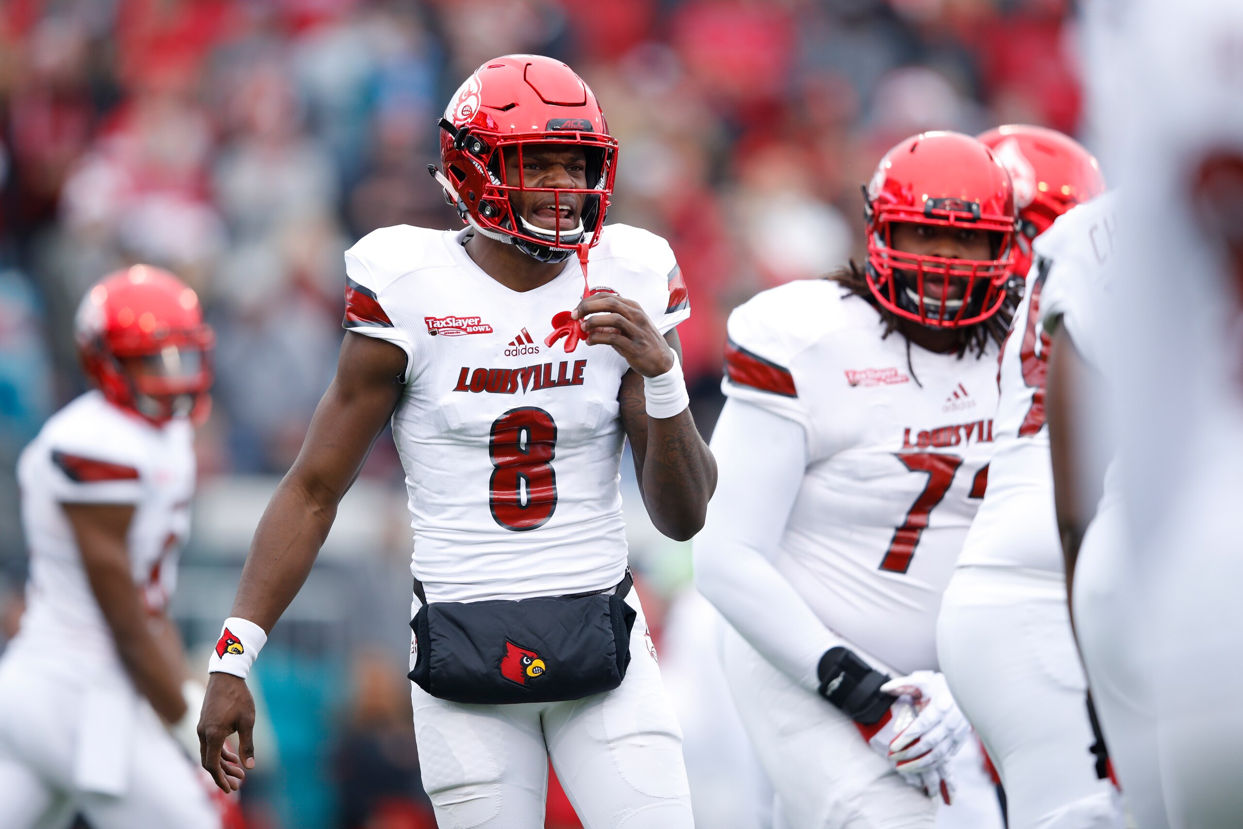 JACKSONVILLE, FL - DECEMBER 30: Lamar Jackson #8 of the Louisville Cardinals directs the offense against the Mississippi State Bulldogs during the TaxSlayer Bowl at EverBank Field on December 30, 2017 in Jacksonville, Florida. The Bulldogs won 31-27. (Pho