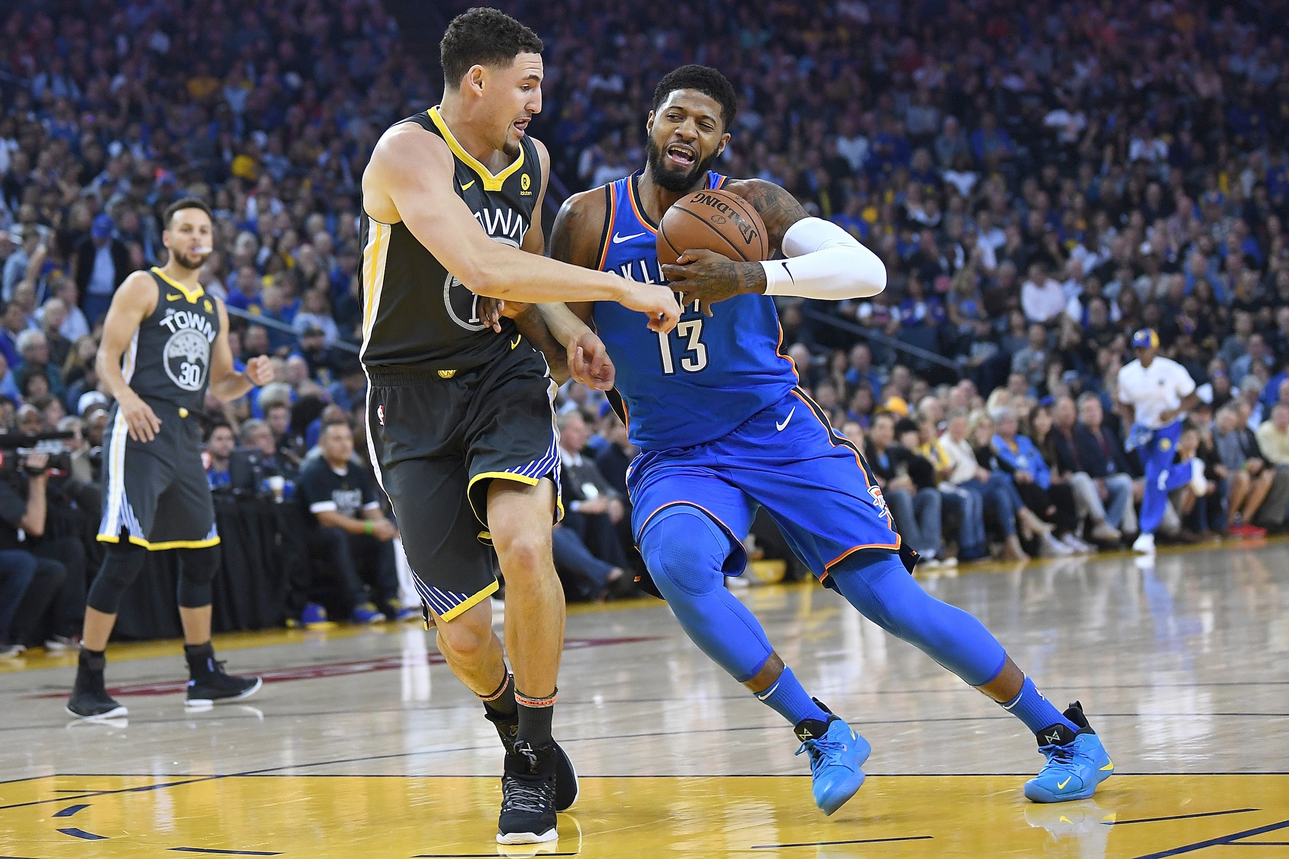 OAKLAND, CA - FEBRUARY 06: Paul George #13 of the Oklahoma City Thunder drives on Klay Thompson #11 of the Golden State Warriors during the first half of an NBA basketball game at ORACLE Arena on February 6, 2018 in Oakland, California. NOTE TO USER: Use OAKLAND, CA - FEBRUARY 06: Paul George #13 of the Oklahoma City Thunder drives on Klay Thompson #11 of the Golden State Warriors during the first half of an NBA basketball game at ORACLE Arena on February 6, 2018 in Oakland, California. NOTE TO USER: Use