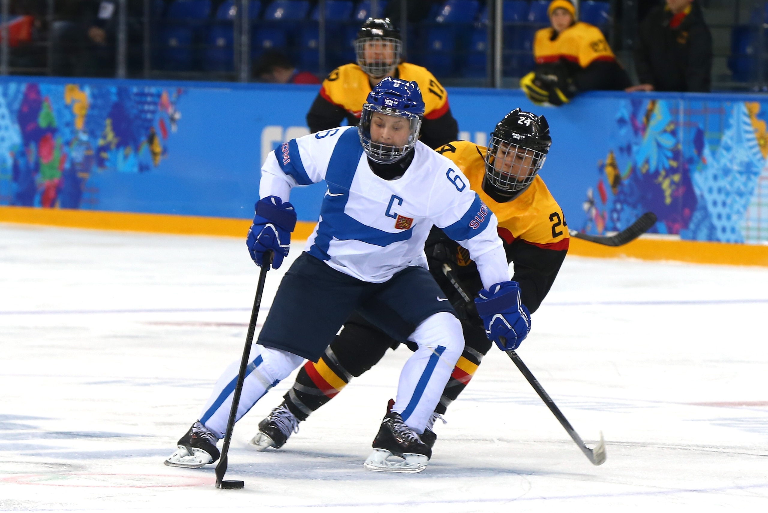 SOCHI, RUSSIA - FEBRUARY 16: Jenni Hiirikoski #6 of Finland handles the puck against Lisa Christine Schuster #24 of Germany during the Women's Ice Hockey Classification game on day nine of the Sochi 2014 Winter Olympics at Shayba Arena on February 16, 201 SOCHI, RUSSIA - FEBRUARY 16: Jenni Hiirikoski #6 of Finland handles the puck against Lisa Christine Schuster #24 of Germany during the Women's Ice Hockey Classification game on day nine of the Sochi 2014 Winter Olympics at Shayba Arena on February 16, 201