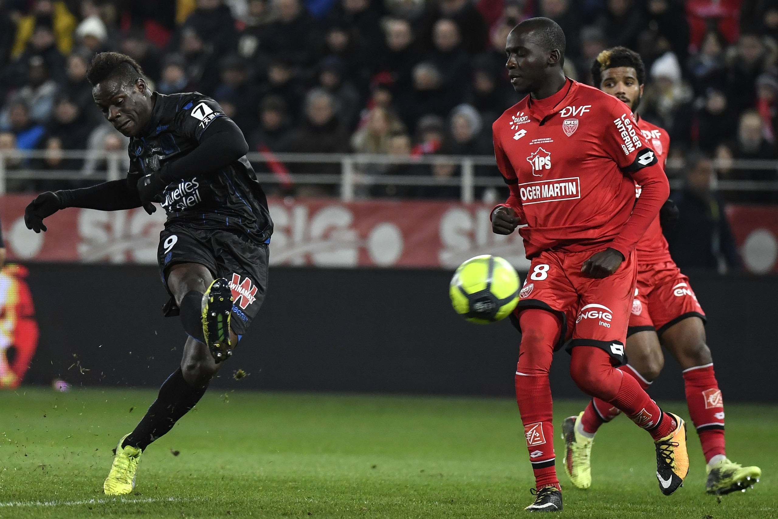 Nice's Italian forward Mario Balotelli (L) vies with Dijon's French-Algerian midfielder Mehdi Abeid during the French L1 football match between Dijon FCO and OGC Nice on February 10, 2018 at the Gaston Gerard stadium in Dijon, central-eastern France.   / 