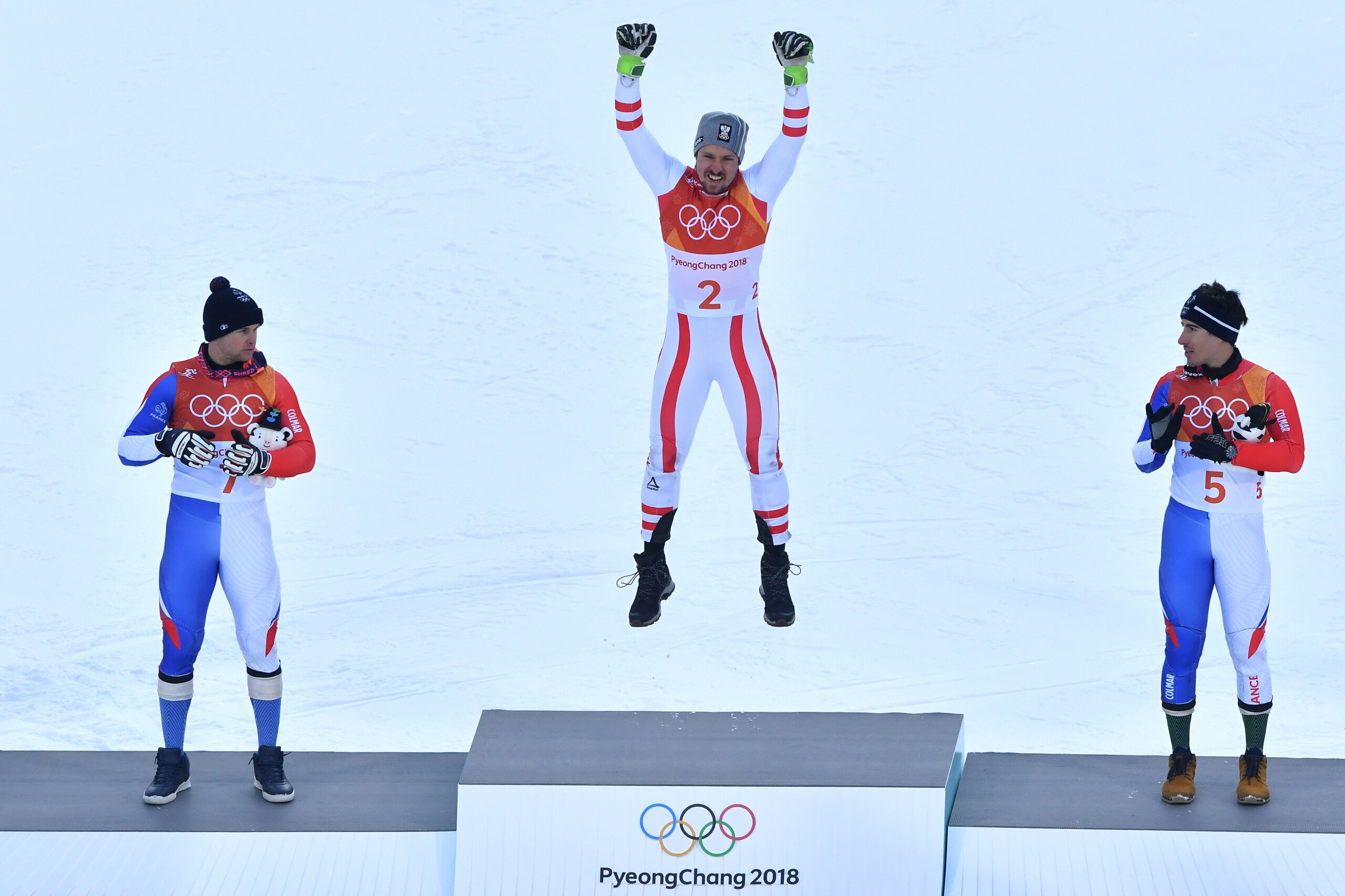Gold medallist, Austria's Marcel Hirscher (C) celebrates on the podium next to France's Alexis Pinturault (L), silver medal, and France's Victor Muffat-Jeandet, bronze, during the victory ceremony of the Men's Alpine Combined at the Jeongseon Alpine Cente