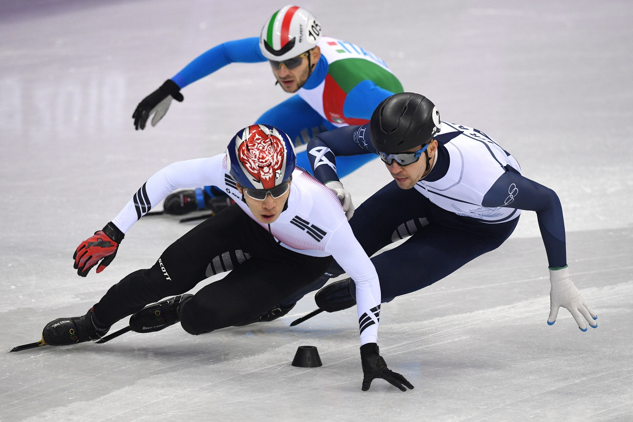 (L-R) South Korea's Hwang Daeheon and Israel's Vladislav Bykanov compete in the men's 1,000m short track speed skating heat event during the Pyeongchang 2018 Winter Olympic Games, at the Gangneung Ice Arena in Gangneung on February 13, 2018. / AFP PHOTO /