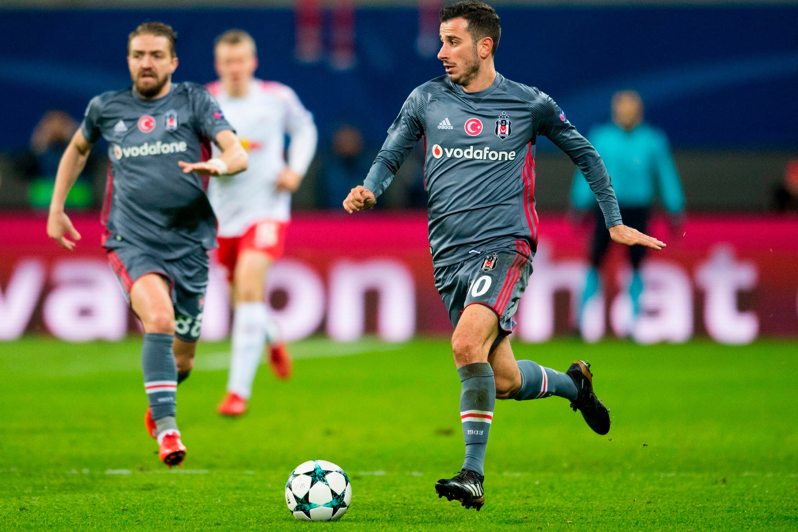 Besiktas' Turkish midfielder Oguzhan Ozyakup (R) plays the ball during the UEFA Champions League group G football match RB Leipzig vs Besiktas in Leipzig, eastern Germany, on December 6, 2017. / AFP PHOTO / ROBERT MICHAEL        (Photo credit should read 