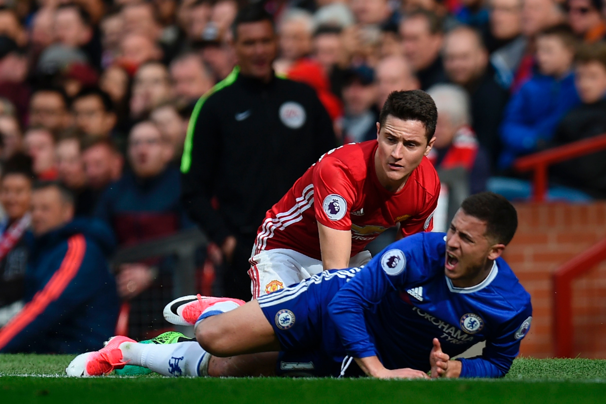 Manchester United's Spanish midfielder Ander Herrera (L) goes down in a challenge with Chelsea's Belgian midfielder Eden Hazard (R) during the English Premier League football match between Manchester United and Chelsea at Old Trafford in Manchester, north