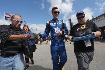 DAYTONA BEACH, FL - FEBRUARY 16:  Alex Bowman, driver of the #88 Nationwide Chevrolet, signs autographs during practice for the Monster Energy NASCAR Cup Series Daytona 500 at Daytona International Speedway on February 16, 2018 in Daytona Beach, Florida. 