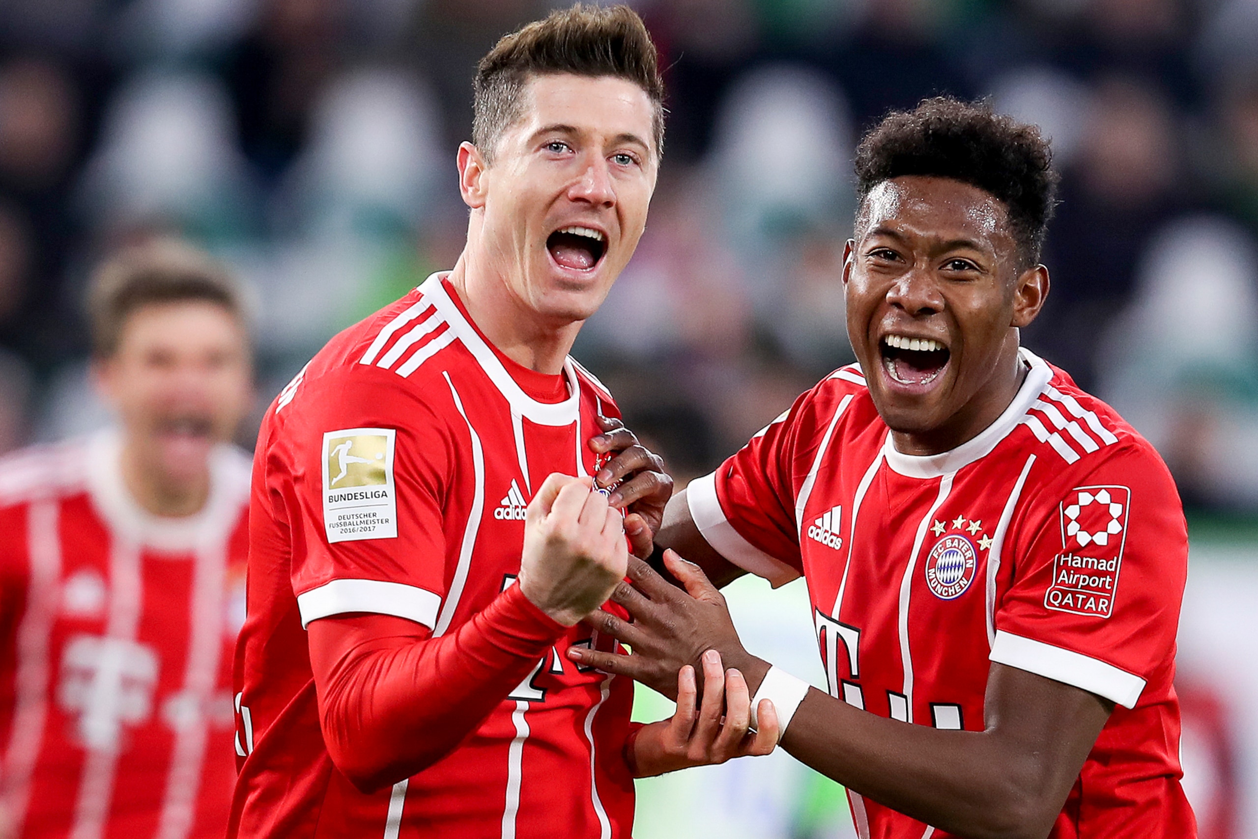 Bayern Munich's Polish forward Robert Lewandowski (L) celebrates with Bayern Munich's Austrian midfielder David Alaba (R) after scoring his team's second goal during the German first division Bundesliga football match between VfL Wolfsburg and FC Bayern M