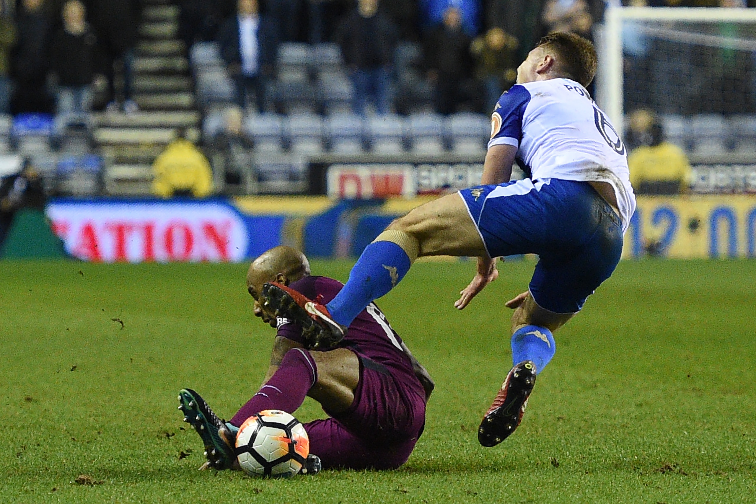 Manchester City's English midfielder Fabian Delph (L) tackle on Wigan Athletic's English midfielder Max Power leads to a red card during the English FA Cup fifth round football match between Wigan Athletic and Manchester City at the DW Stadium in Wigan, n