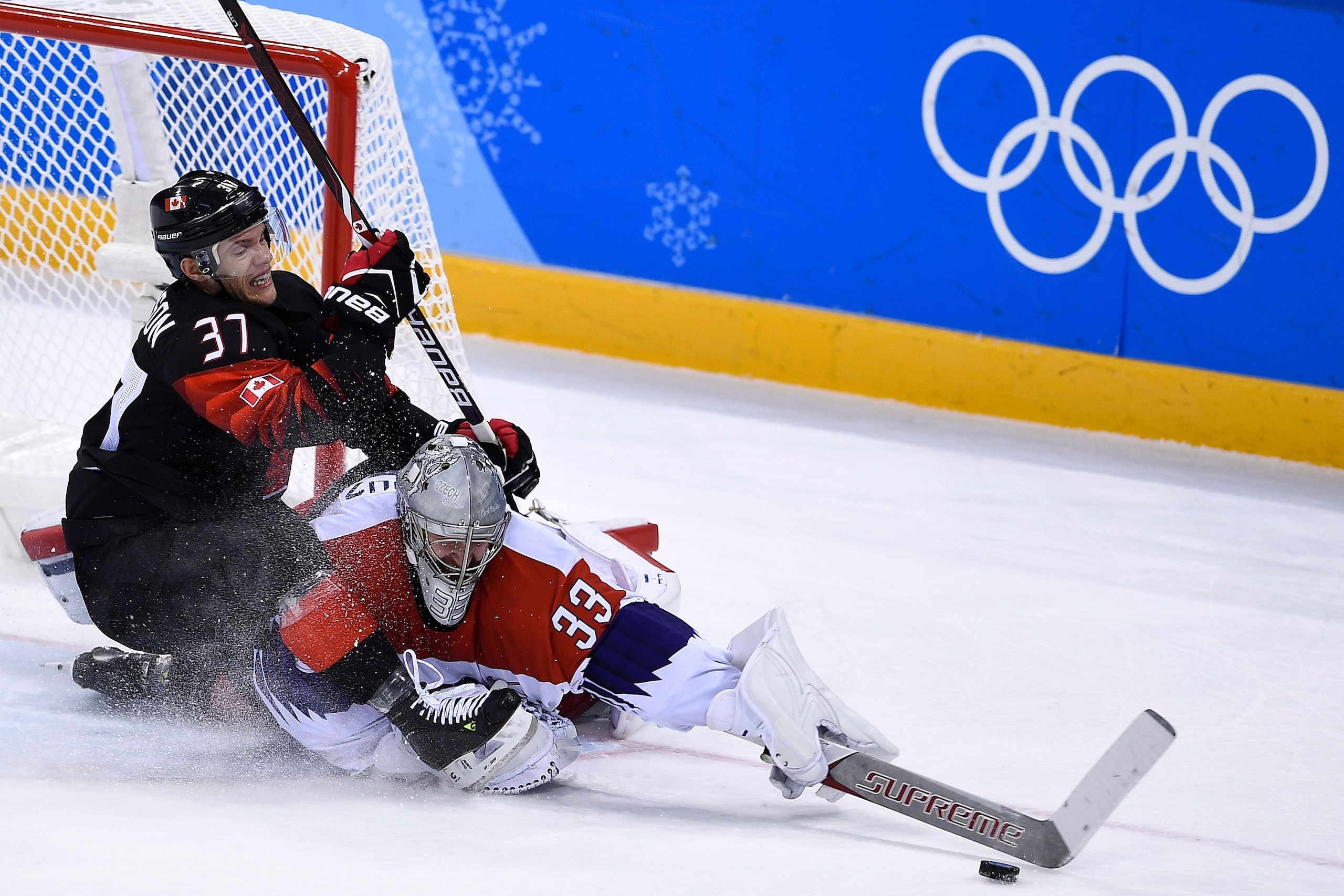TOPSHOT - Canada's Mat Robinson (L) and Czech Republic's Pavel Francouz fight for the puck during overtime in the men's preliminary round ice hockey match between Canada and Czech Republic during the Pyeongchang 2018 Winter Olympic Games at the Gangneung 