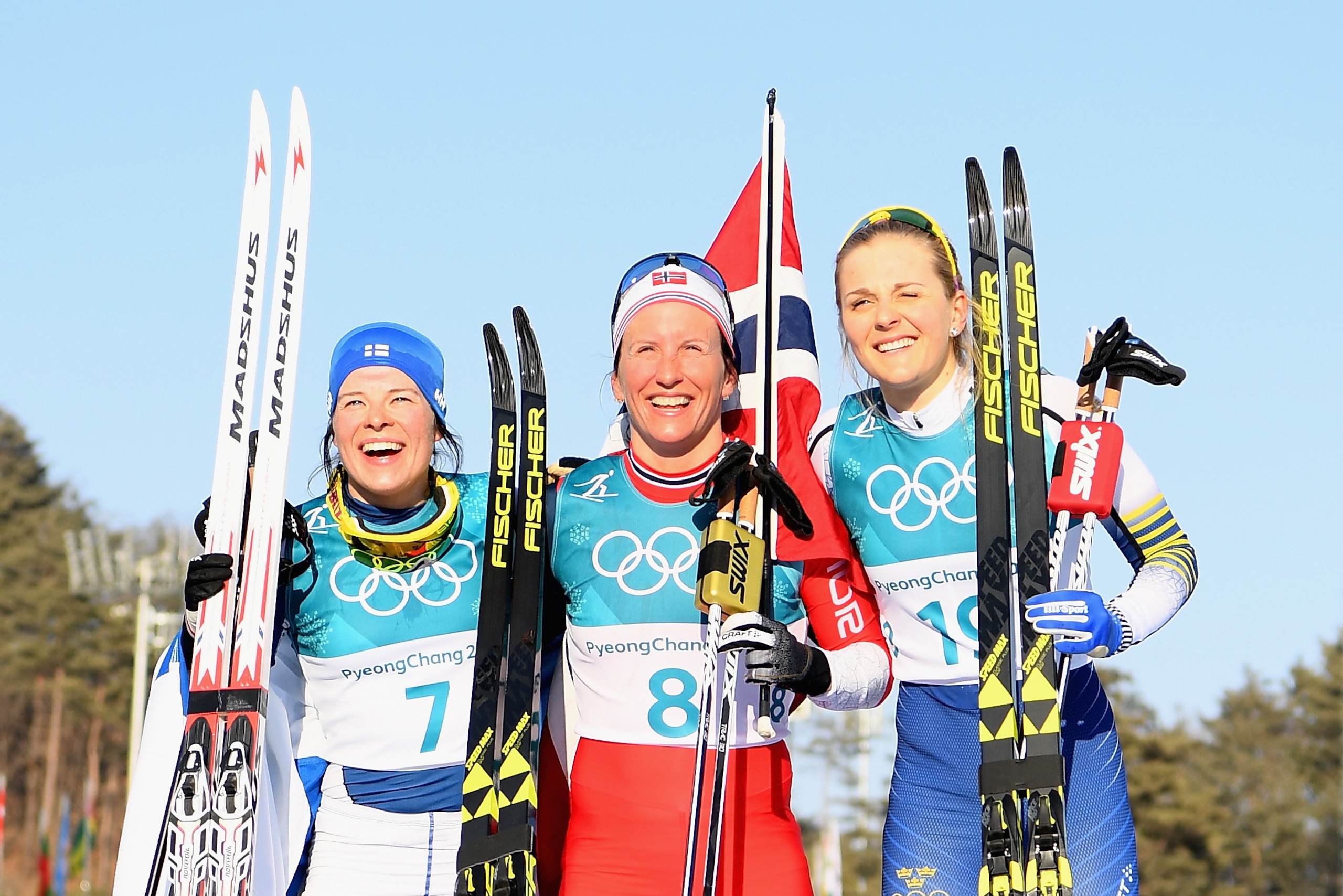 PYEONGCHANG-GUN, SOUTH KOREA - FEBRUARY 25:  (L-R) Second placed Krista Parmakoski of Finland, first placed Marit Bjoergen of Norway and third placed Stina Nilsson of Sweden celebrate following the Ladies' 30km Mass Start Classic on day sixteen of the Pye