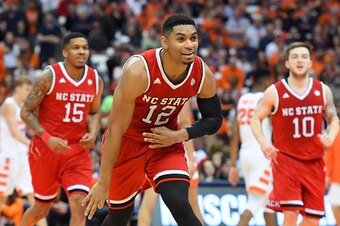 SYRACUSE, NY - FEBRUARY 14:  Allerik Freeman #12 of the North Carolina State Wolfpack reacts to a made three-point basket during a time-out against the Syracuse Orange in the first half at the Carrier Dome on February 14, 2018 in Syracuse, New York. (Phot