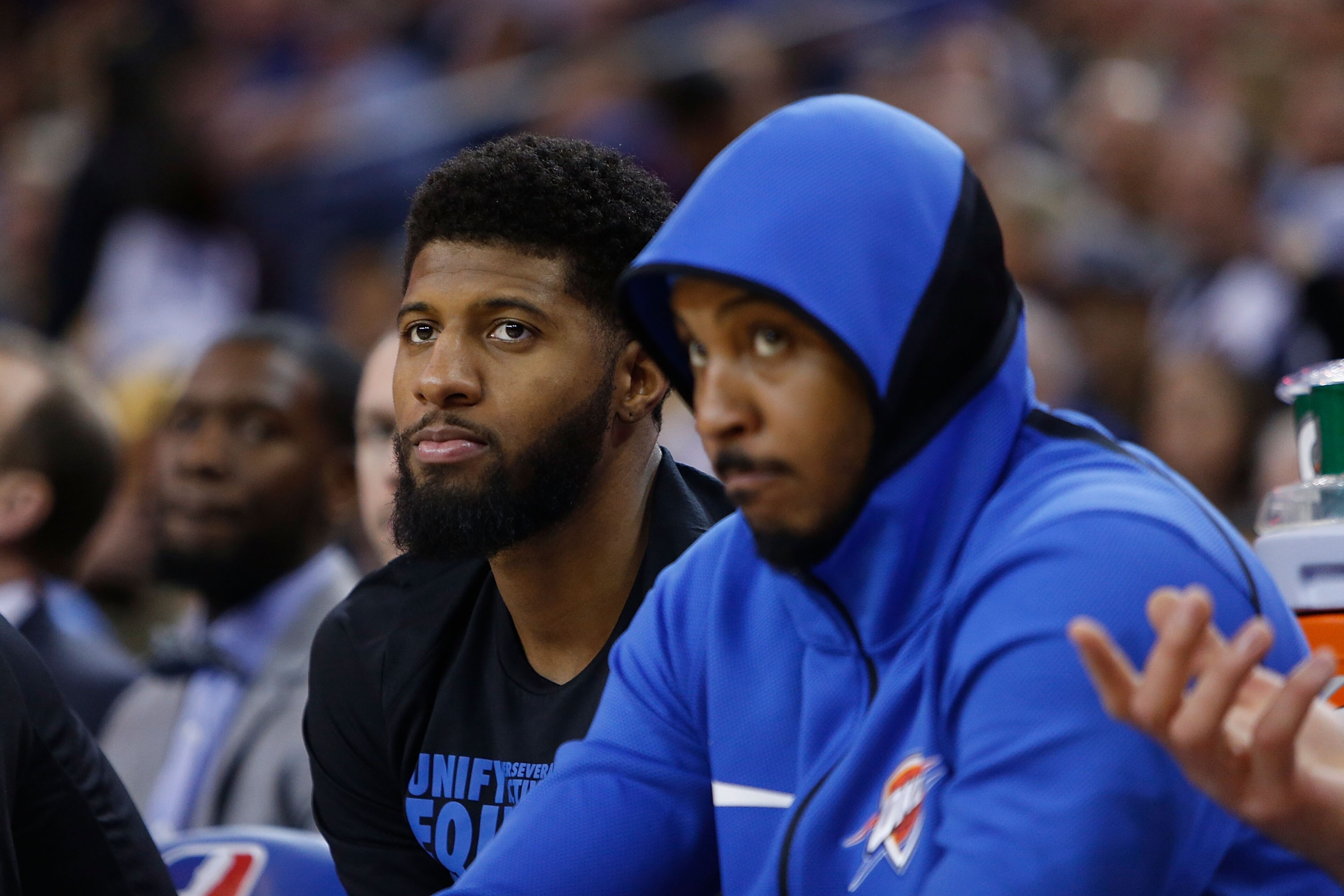 OAKLAND, CA - FEBRUARY 24: Paul George #13 and Carmelo Anthony #7 of the Oklahoma City Thunder look on from the bench during the game against the Golden State Warriors at ORACLE Arena on February 24, 2018 in Oakland, California. NOTE TO USER: User express