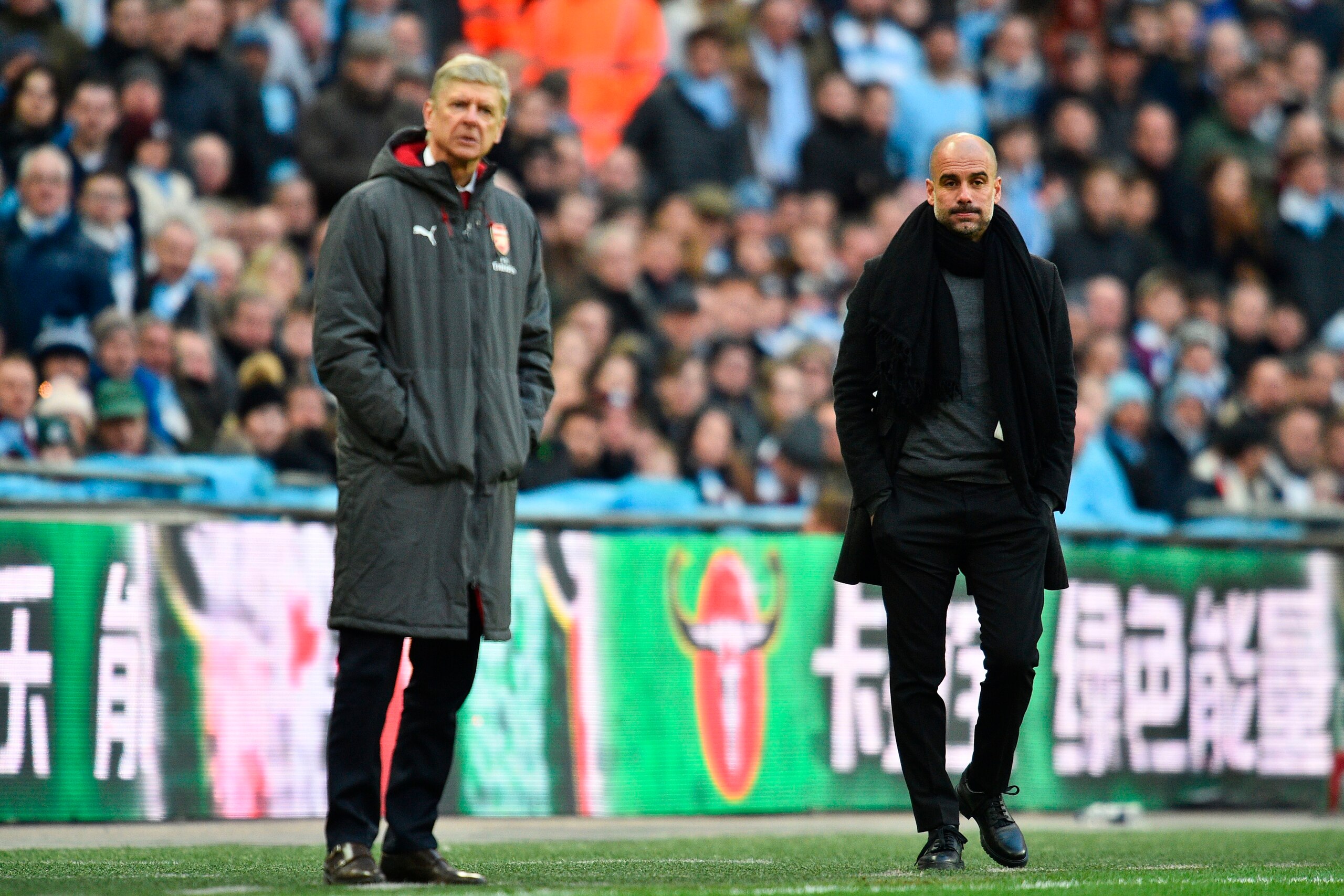 Manchester City's Spanish manager Pep Guardiola (R) and Arsenal's French manager Arsene Wenger (L) watch from the touchline during the English League Cup final football match between Manchester City and Arsenal at Wembley stadium in north London on Februa