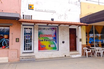 The lottery shop that Dybala's parents ran during his childhood with the entrance to his childhood home on the right