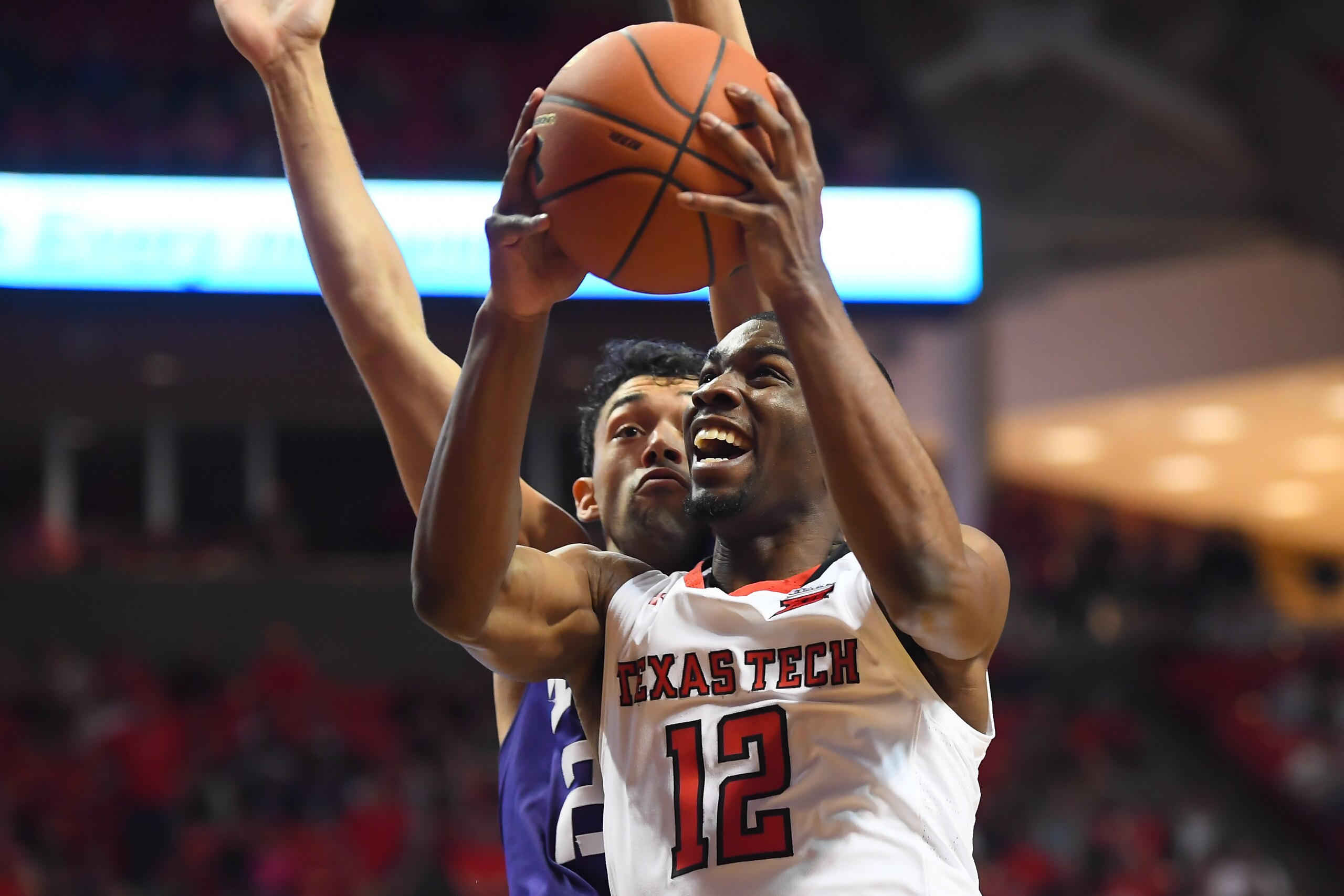 LUBBOCK, TX - MARCH 3: Keenan Evans #12 of the Texas Tech Red Raiders goes to the basket against Alex Robinson #25 of the TCU Horned Frogs during the second half of the game on March 3, 2018 at United Supermarket Arena in Lubbock, Texas. Texas Tech defeat