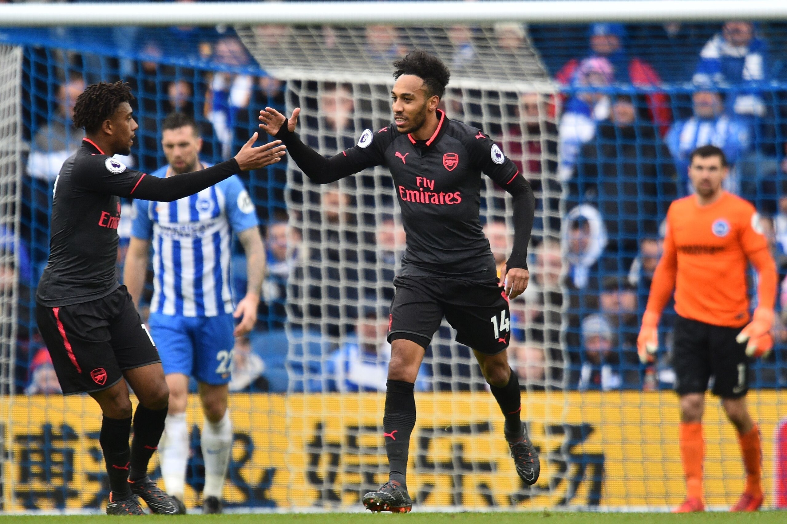 Arsenal's Gabonese striker Pierre-Emerick Aubameyang (C) celebrates with Arsenal's Nigerian striker Alex Iwobi after scoring their first goal during the English Premier League football match between Brighton and Hove Albion and Arsenal at the American Exp