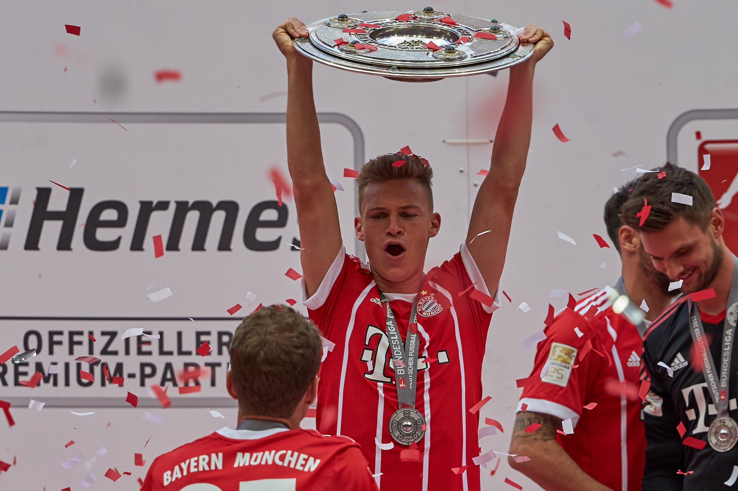 MUNICH, GERMANY - MAY 20: Joshua Kimmich of Bayern Muenchen poses with the Championship trophy in celebration of the 67th German Championship title following the Bundesliga match between Bayern Muenchen and SC Freiburg at Allianz Arena on May 20, 2017 in 