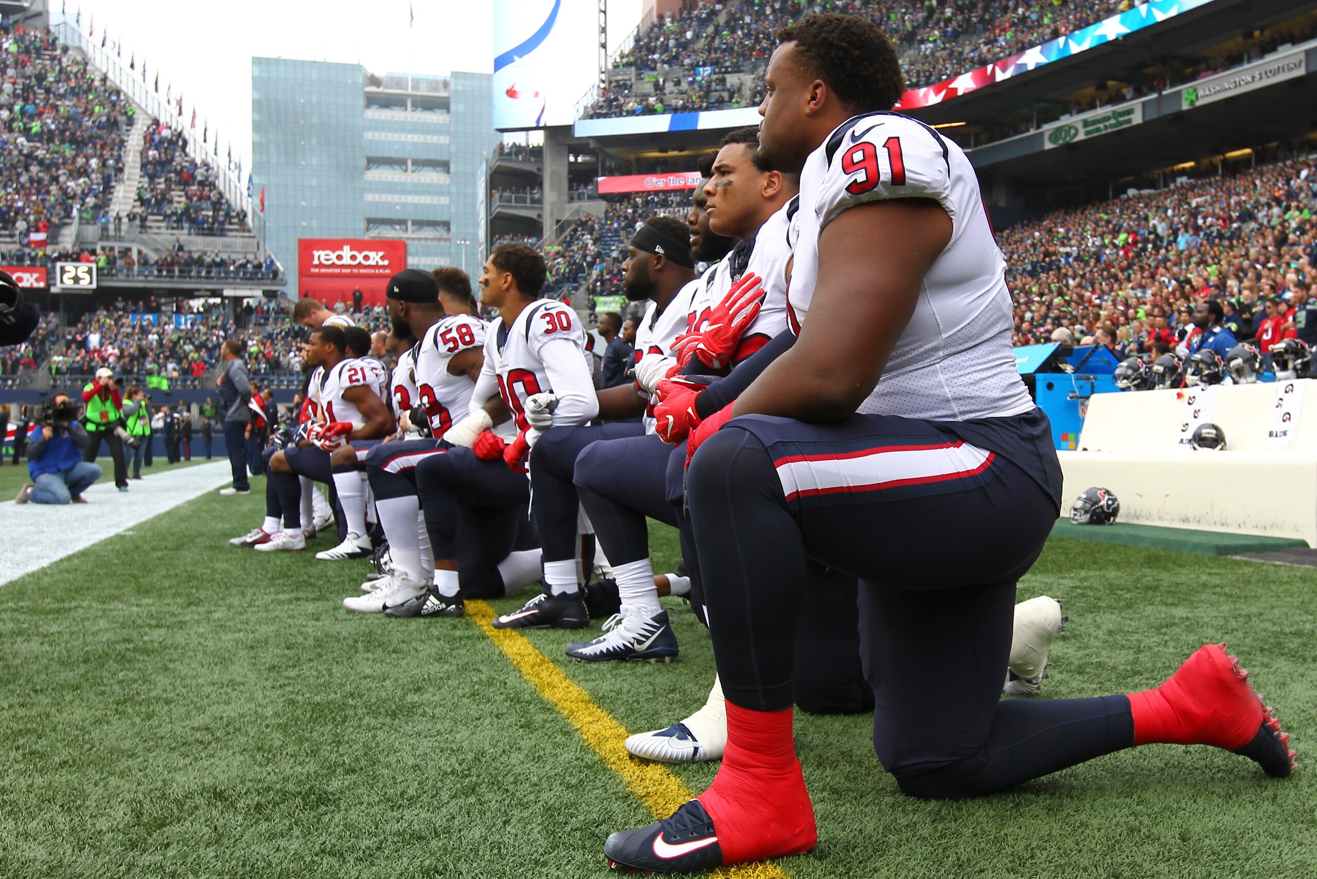 SEATTLE, WA - OCTOBER 29:  Members of the Houston Texans kneel during the national anthem before the game against the Seattle Seahawks at CenturyLink Field on October 29, 2017 in Seattle, Washington. During a meeting of NFL owners earlier in October, Hous